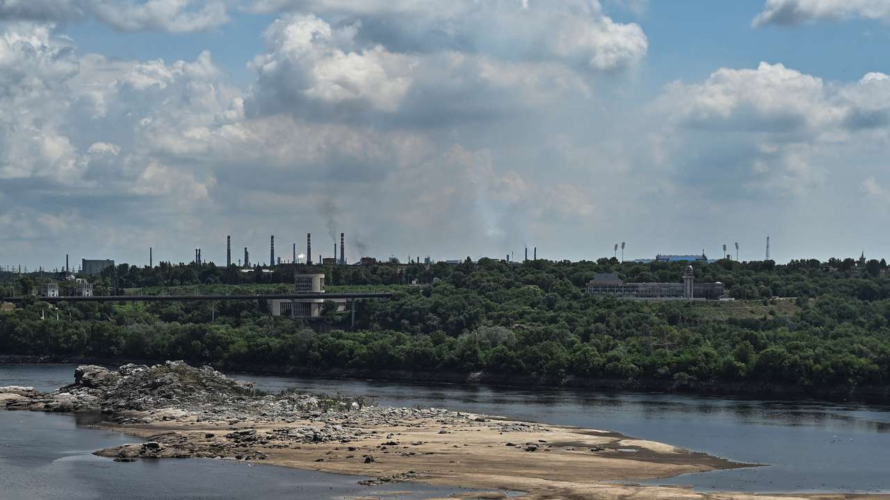 View shows the city skyline and a rocky island in the Dnipro river which became visible again after water level sharply dropped following Kakhovka dam destruction, in Zaporizhzhia
