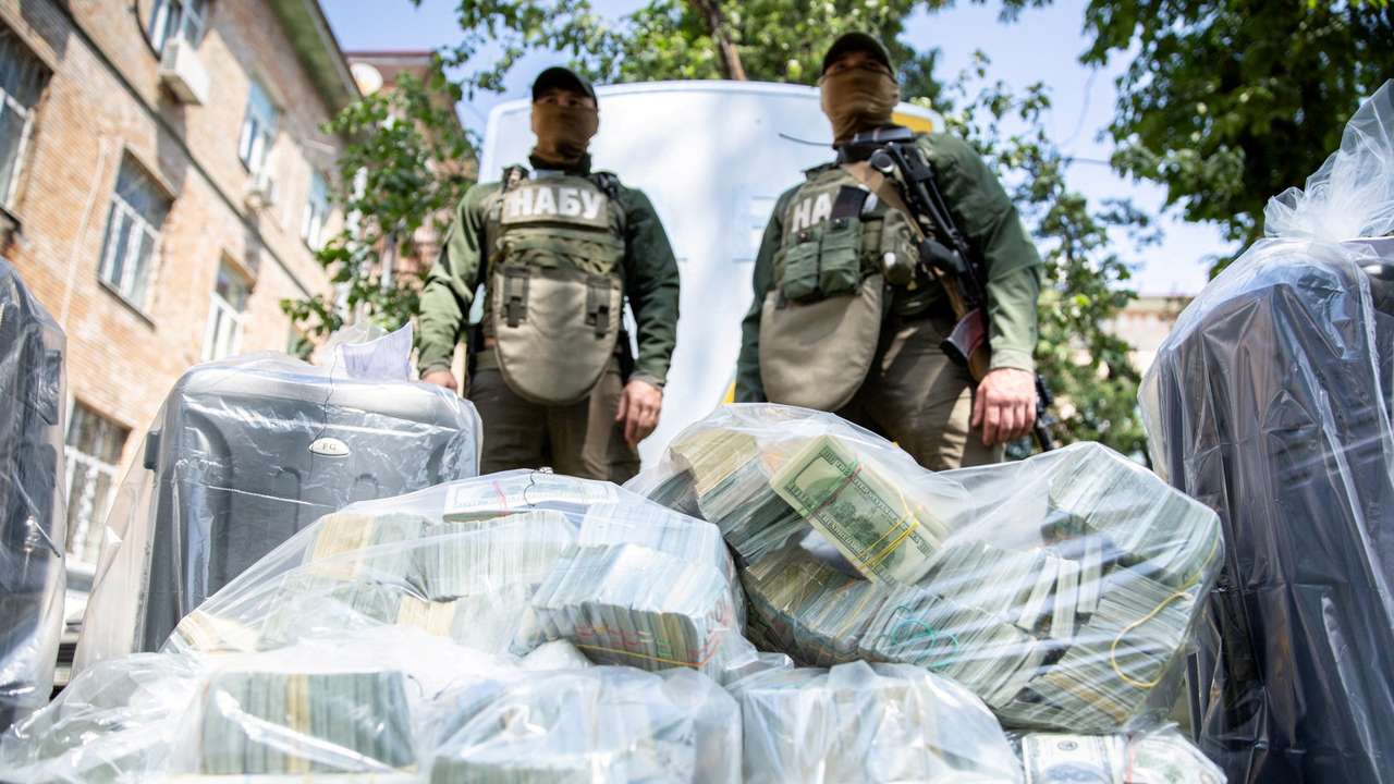 Officers of the National Anti-Corruption Bureau of Ukraine stand next to plastic bags filled with seized U.S. Dollar banknotes in Kiev