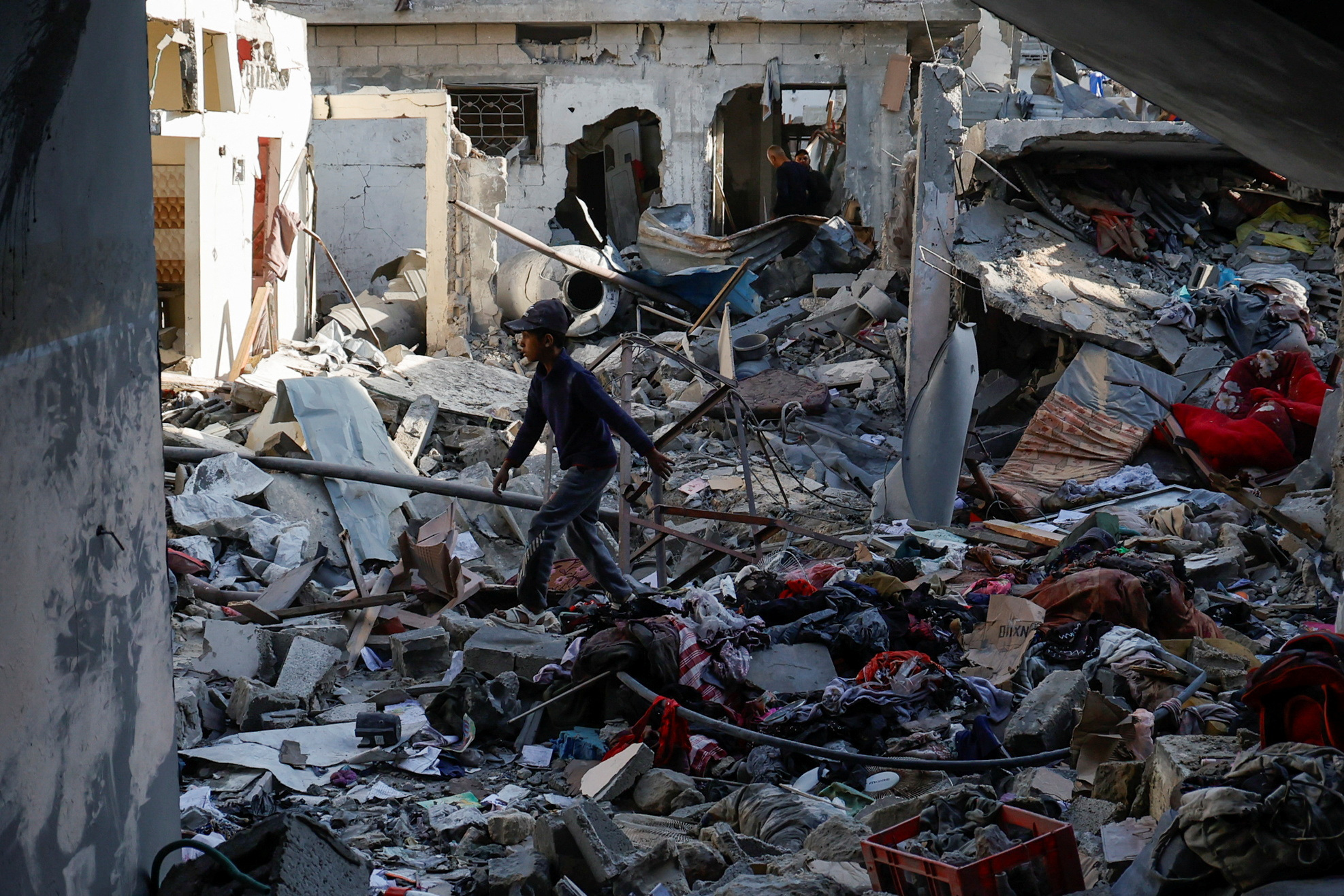Palestinians inspect the site of an Israeli strike on a house, in Khan Younis in the southern Gaza Strip