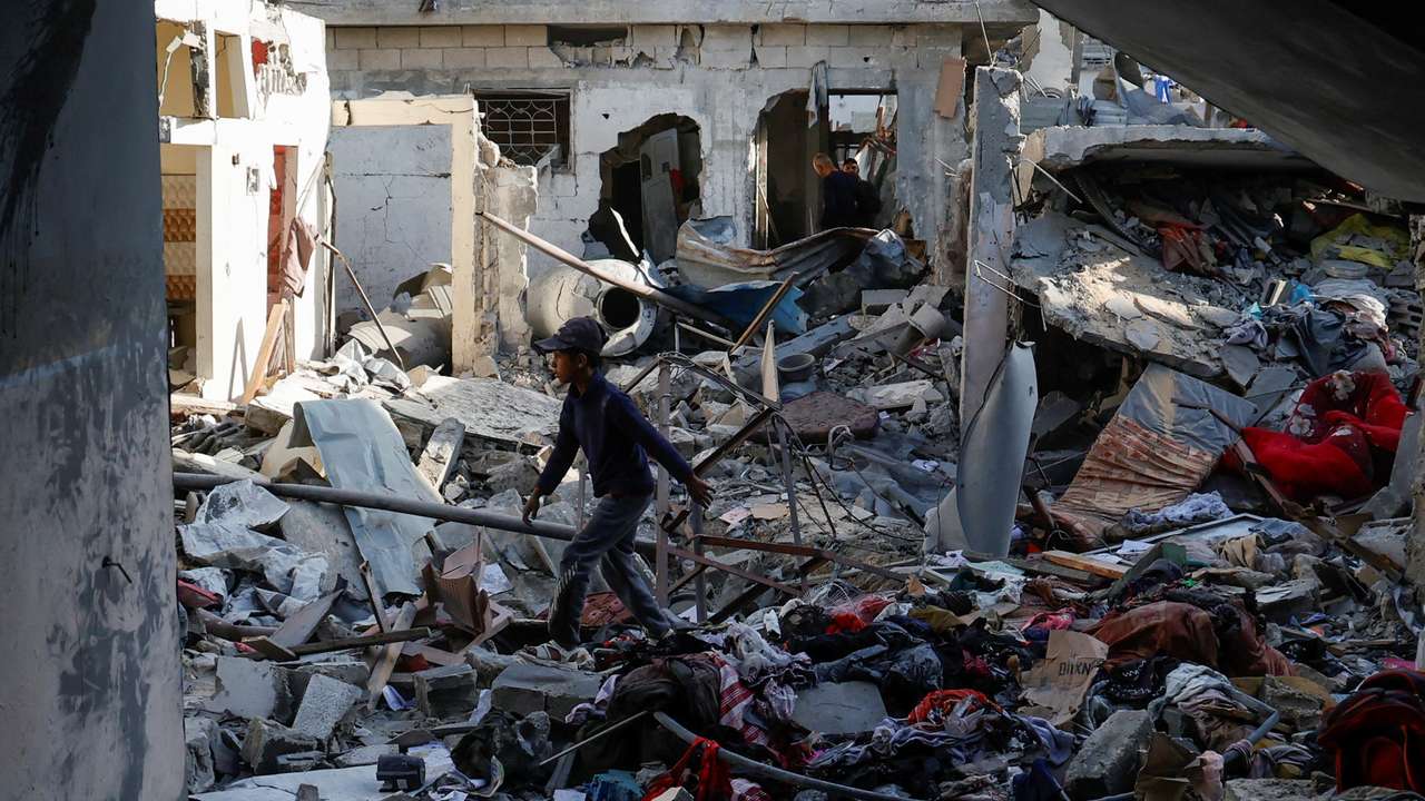 Palestinians inspect the site of an Israeli strike on a house, in Khan Younis in the southern Gaza Strip