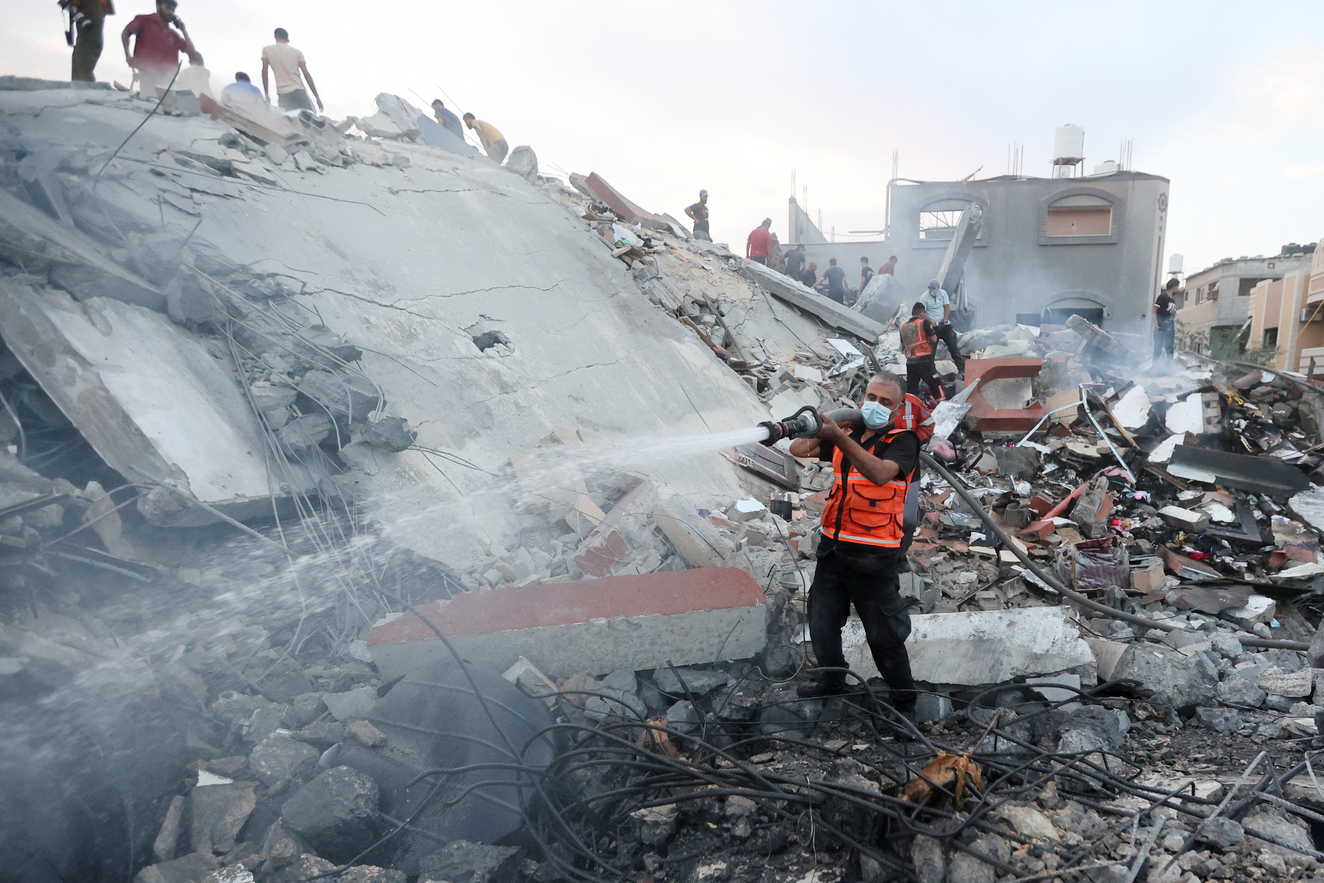 Palestinians search for casualties at the site of Israeli strikes on a residential building