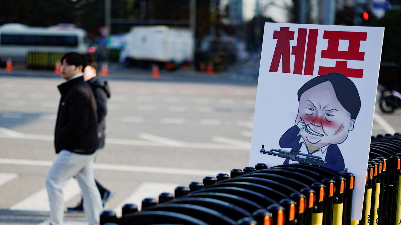 A pedestrian walks past a banner denouncing South Korean President Yoon Suk Yeol, in Seoul