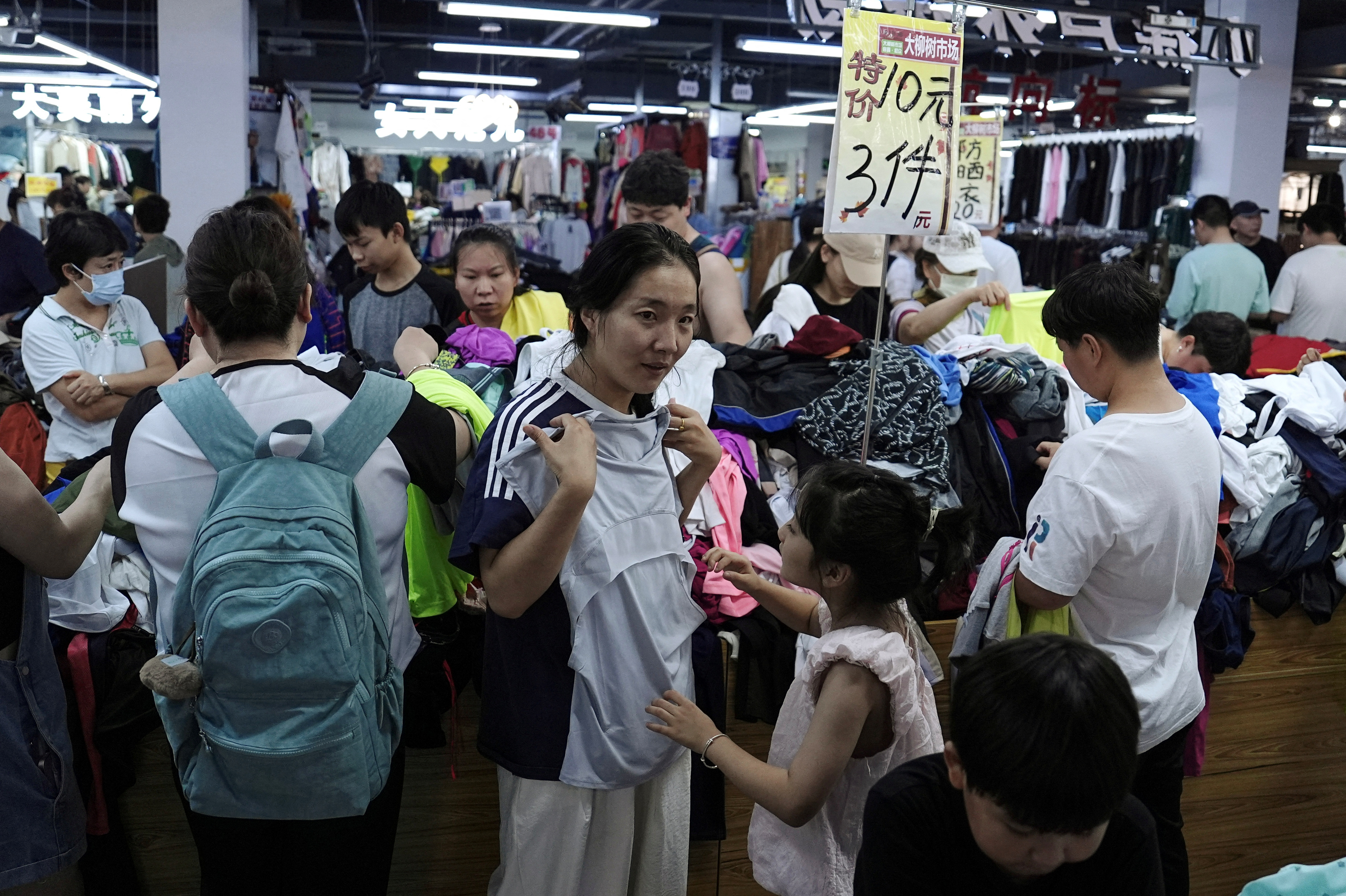 Customers shop at a discount clothing shop in Beijing