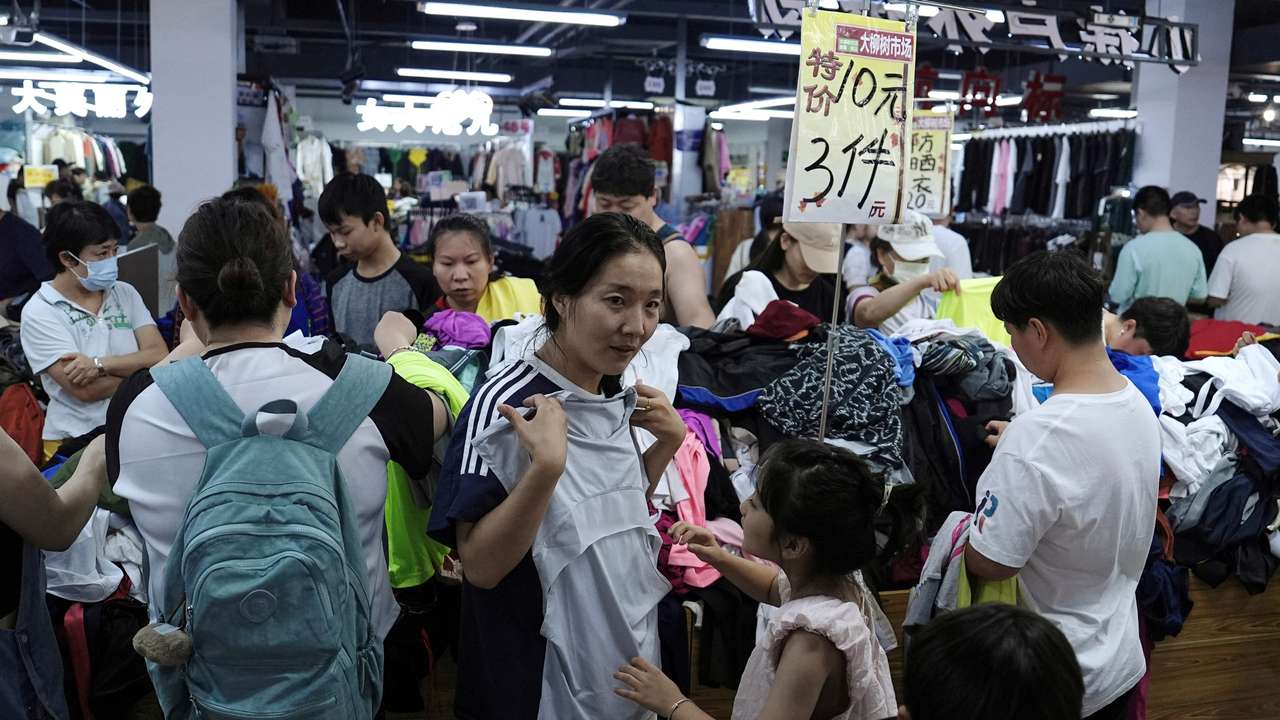 Customers shop at a discount clothing shop in Beijing