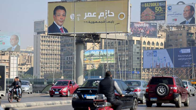 FILE PHOTO: Vehicles drive past posters of presidential candidate and current Egyptian President Abdel Fattah al-Sisi and presidential candidate Hazem Omar, head of the People's Republican Party (PRP), displayed on billboards in Cairo