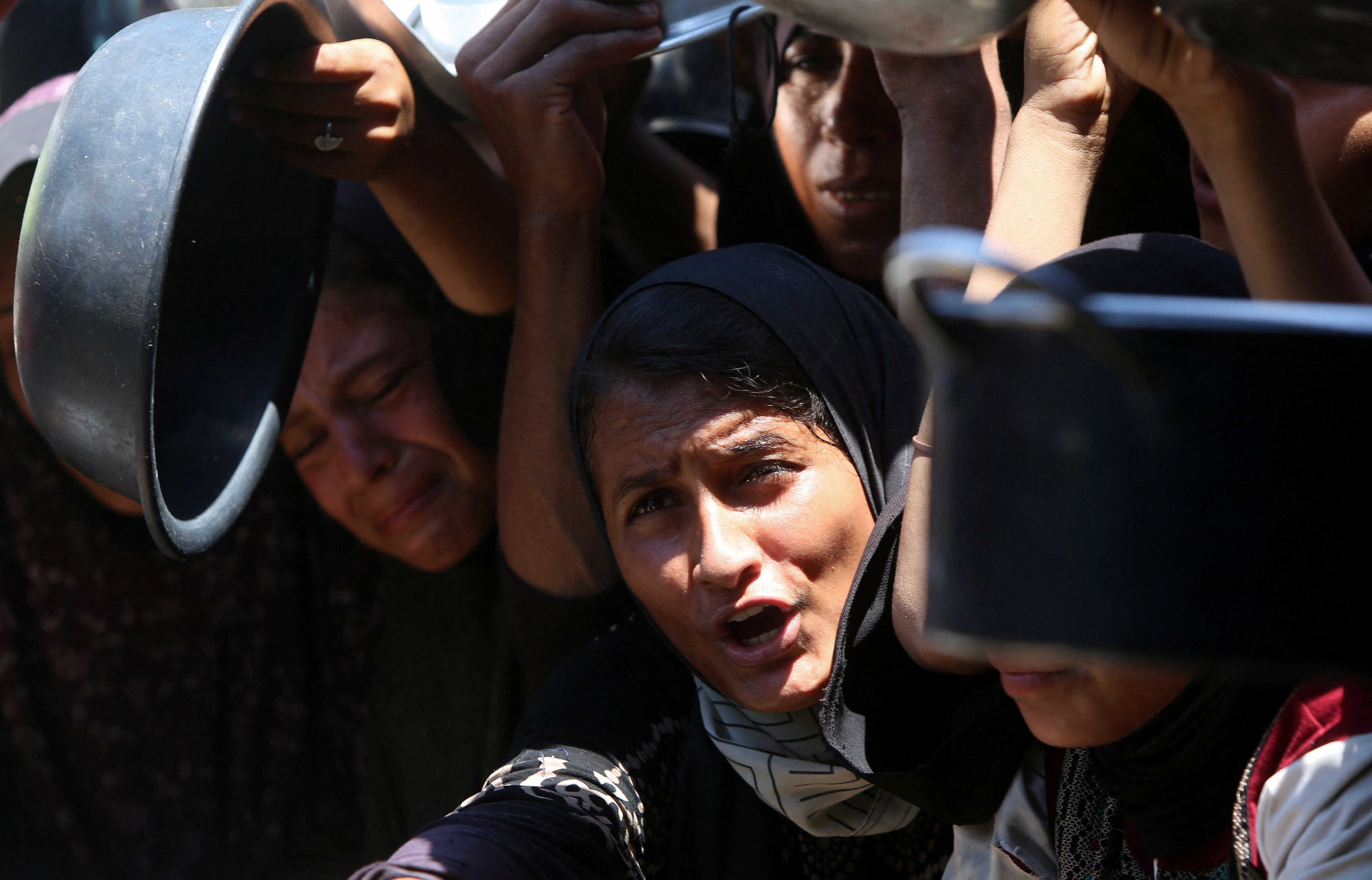 Palestinians wait to receive food from a charity kitchen, amid a hunger crisis, in Khan Younis
