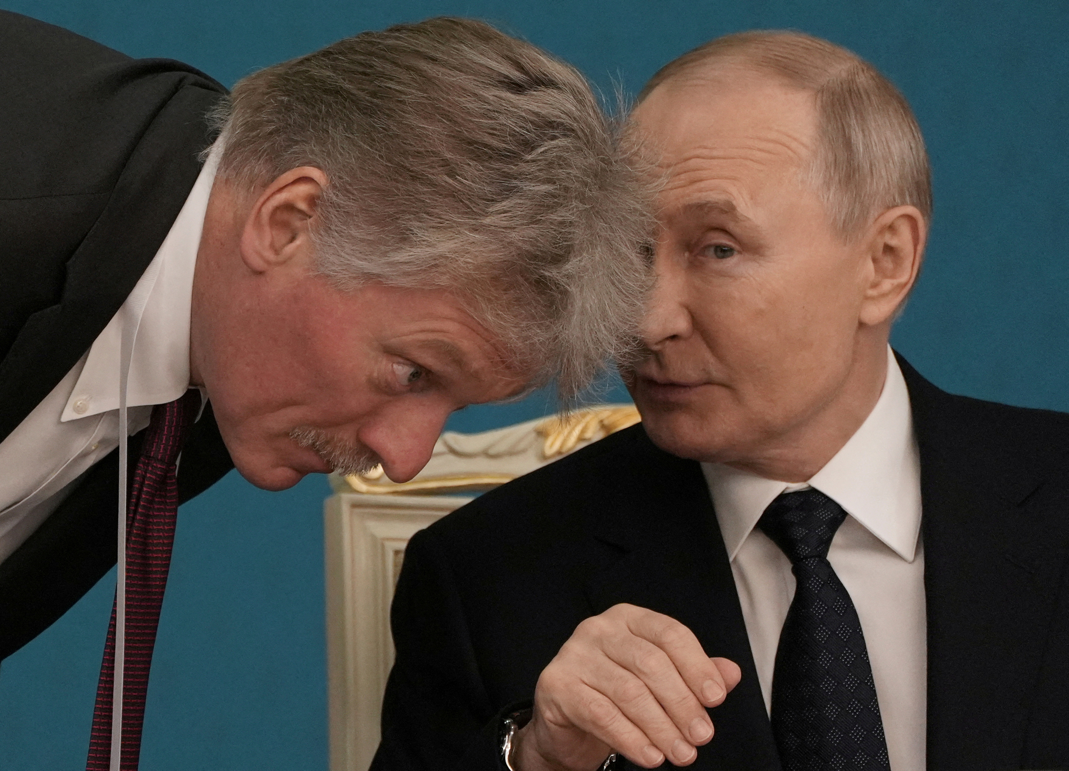 FILE PHOTO: Russian President Vladimir Putin talks to Kremlin spokesman Dmitry Peskov