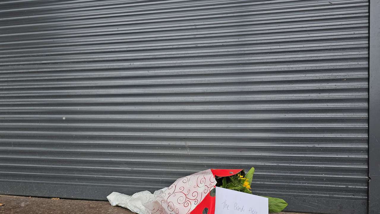 Flowers left outside tobacco shop owned by "Bondi hero" Ahmed al Ahmed, in Sydney
