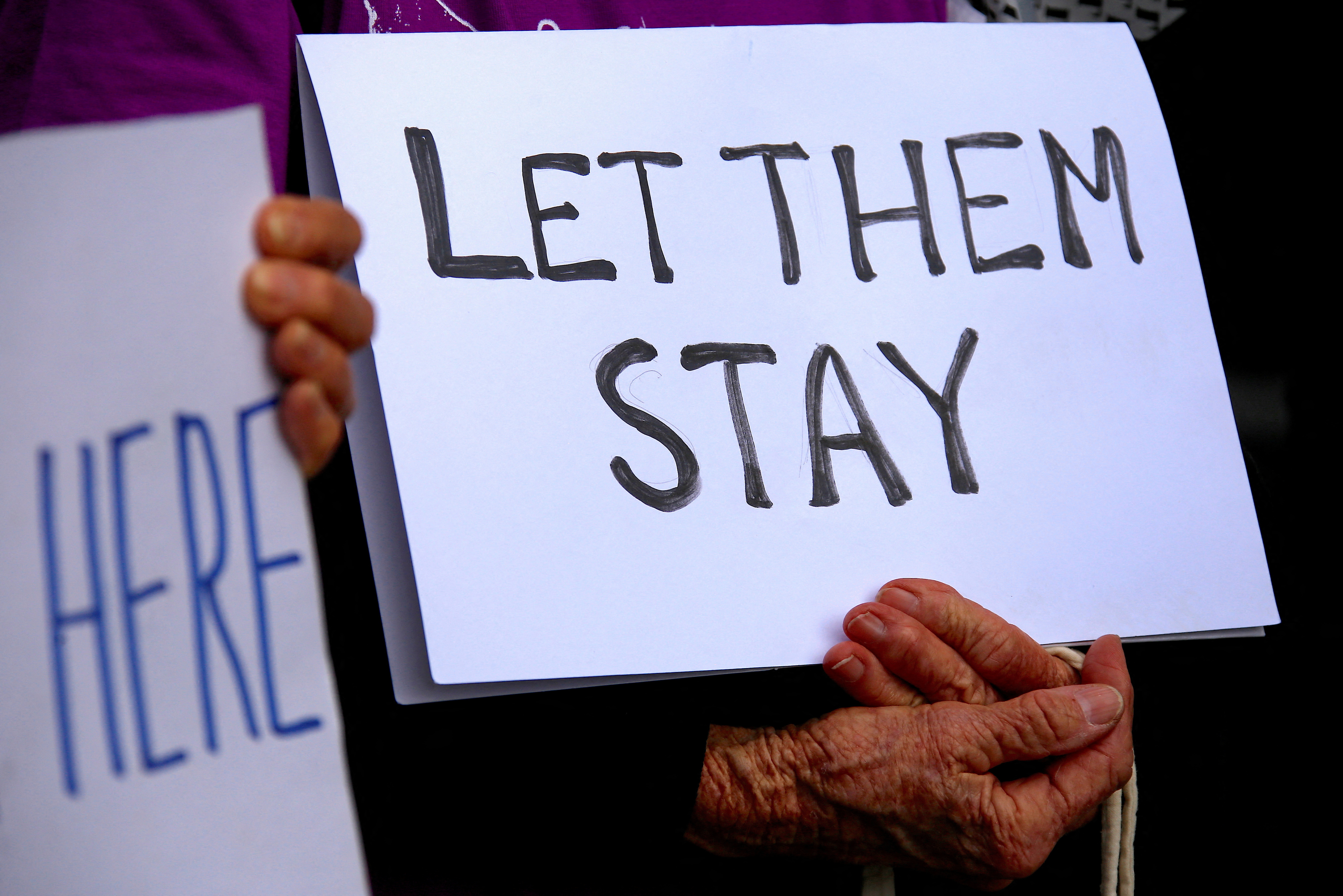 FILE PHOTO: Refugee advocates hold signs as they protest against the detention of asylum seekers being held at Australian-run offshore detention centers located on Papua New Guinea's Manus Island, and the South-Pacific island of Nauru, in central Sydney