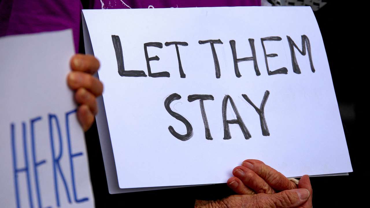 FILE PHOTO: Refugee advocates hold signs as they protest against the detention of asylum seekers being held at Australian-run offshore detention centers located on Papua New Guinea's Manus Island, and the South-Pacific island of Nauru, in central Sydney