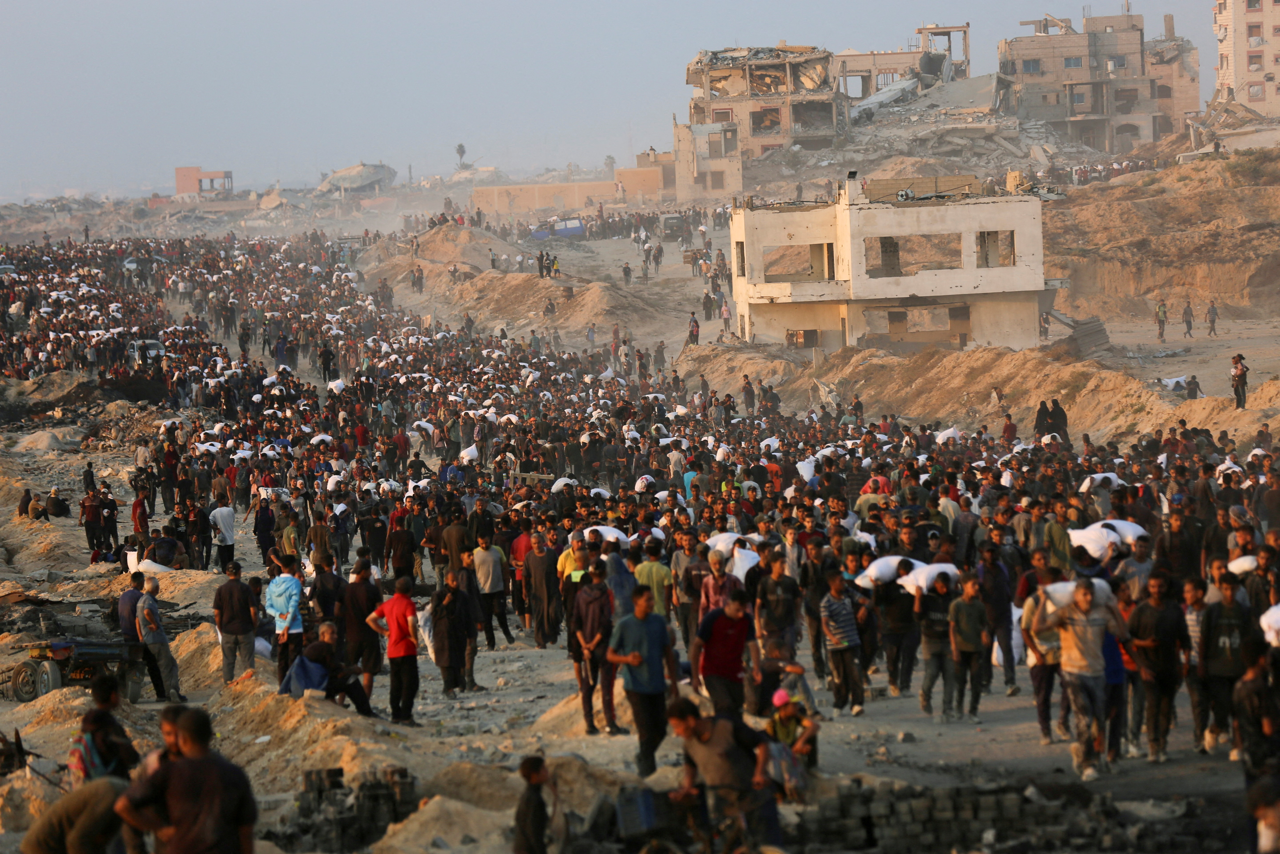 Palestinians gather to receive aid supplies in Beit Lahia