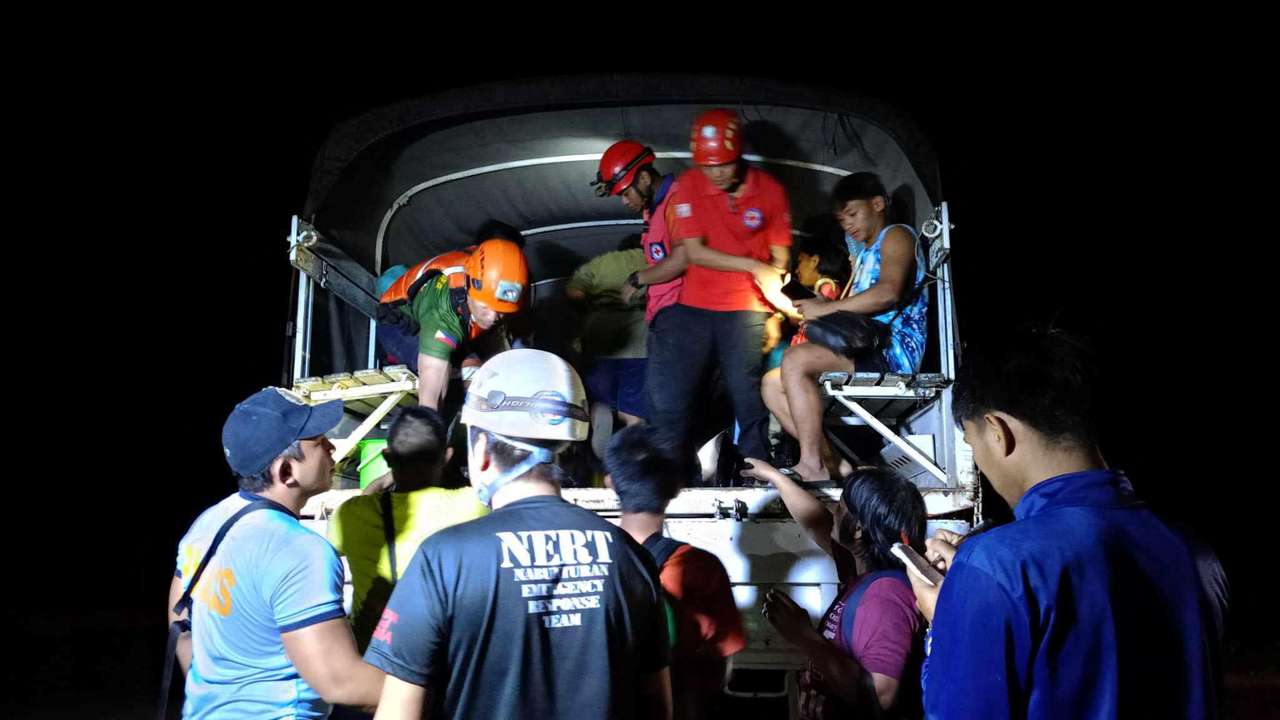 People partake in rescue operations following a landslide in Maco