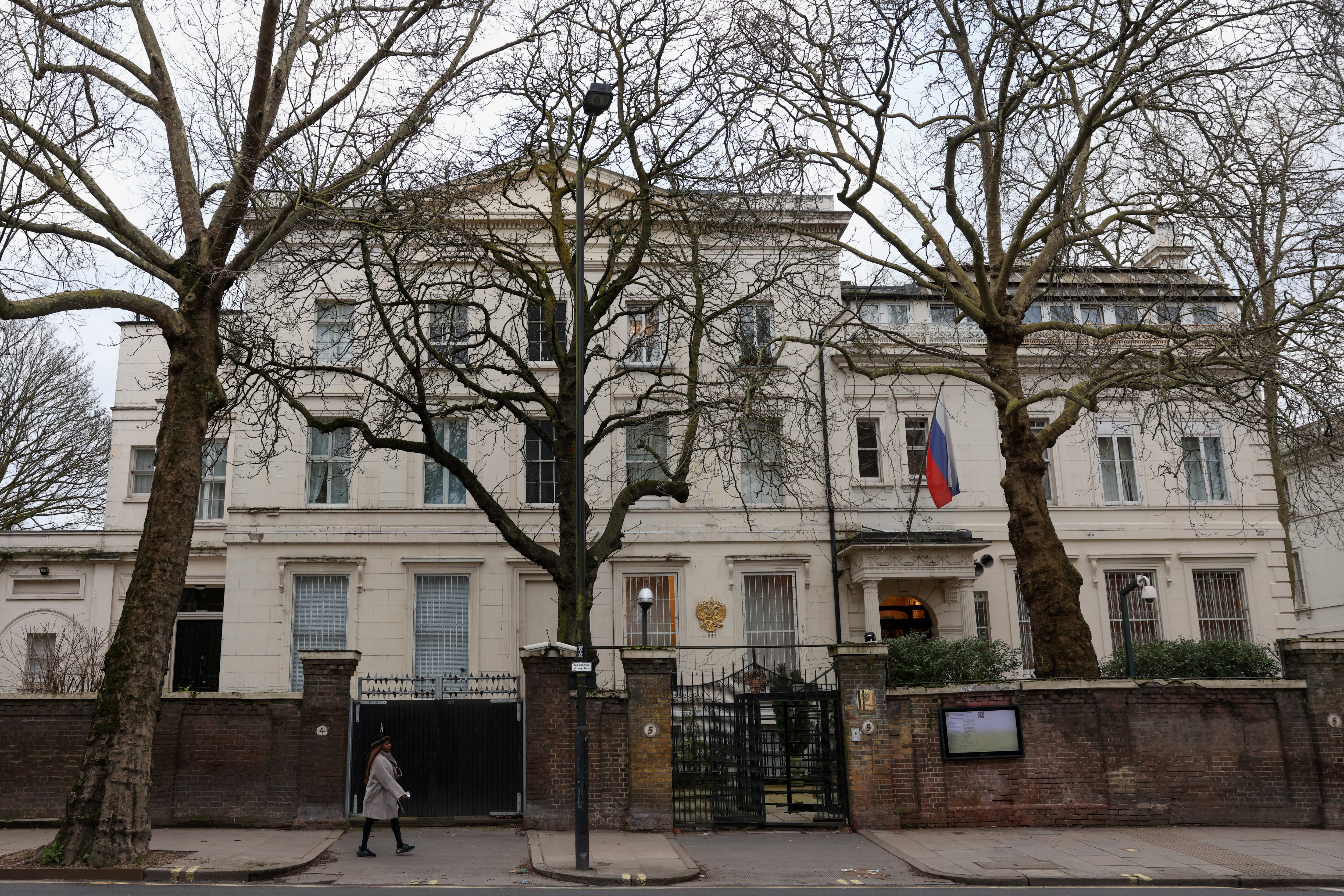 A pedestrian walks past the Russian Embassy following the death of Alexei Navalny, in London