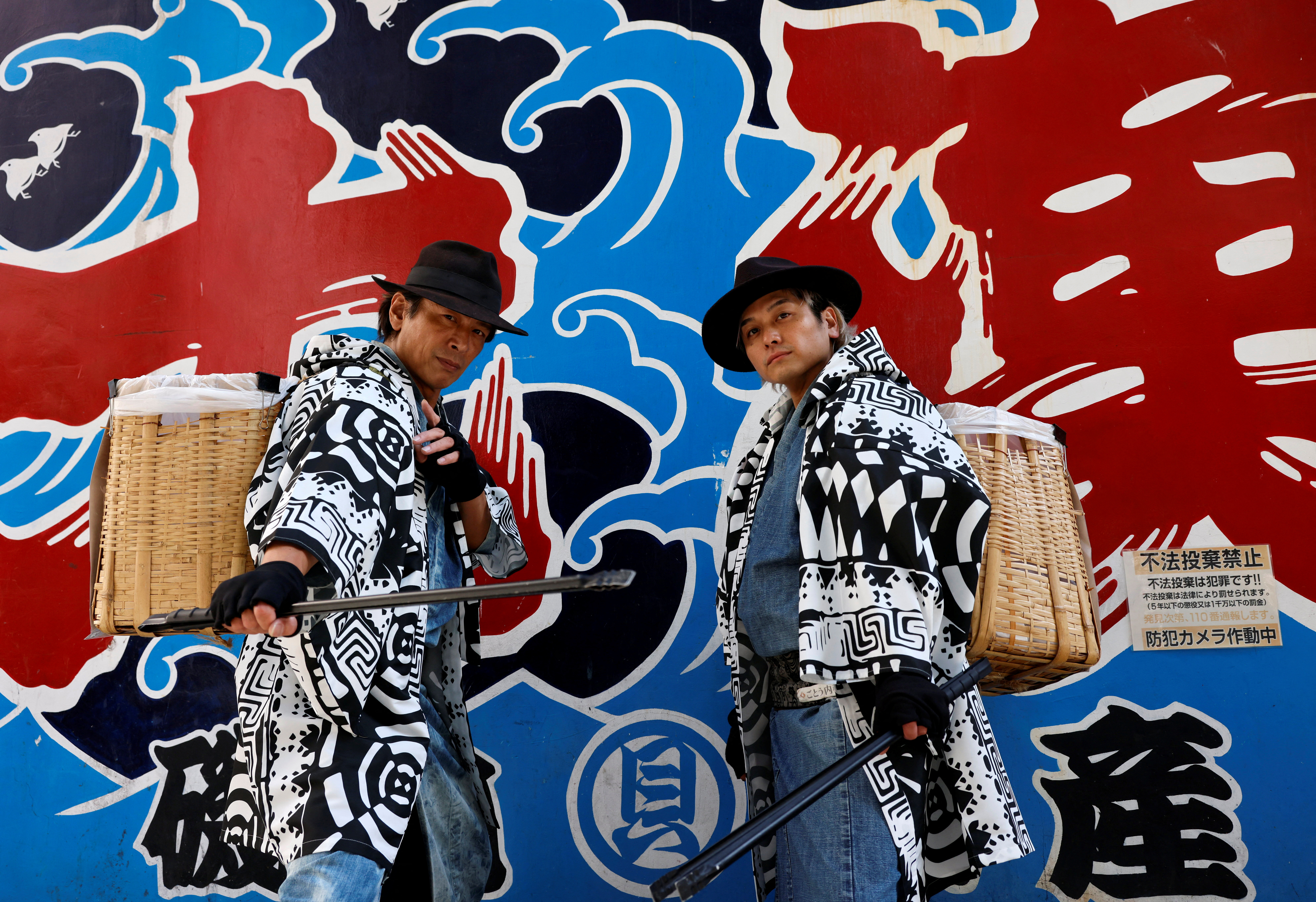 Keisuke Naka and Ikki Goto, members of Gomihiroi Samurai pick up trash on the street in Tokyo