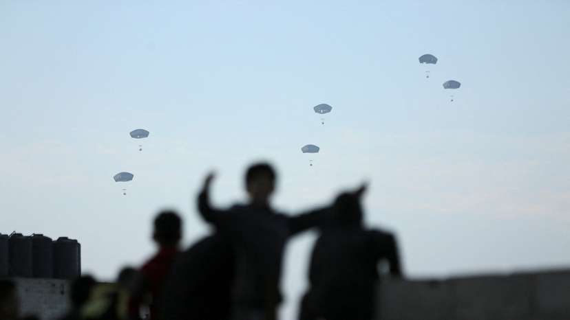 People watch as U.S. military carries out its first aid drop over Gaza, amid the ongoing the conflict between Israel and the Palestinian Islamist group Hamas, in Gaza City