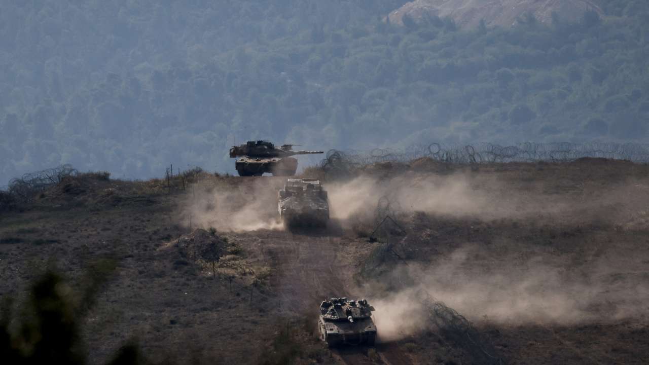 FILE PHOTO: Israeli military vehicles manoeuvre along the Israel-Lebanon border as seen from northern Israel