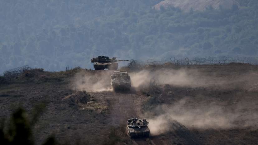 FILE PHOTO: Israeli military vehicles manoeuvre along the Israel-Lebanon border as seen from northern Israel