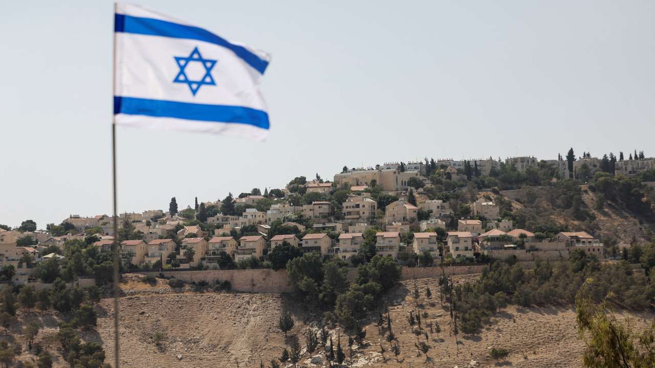 Israeli flag flutters, as part of the Israeli settlement of Maale Adumim is visible in the background, in the Israeli-occupied West Bank
