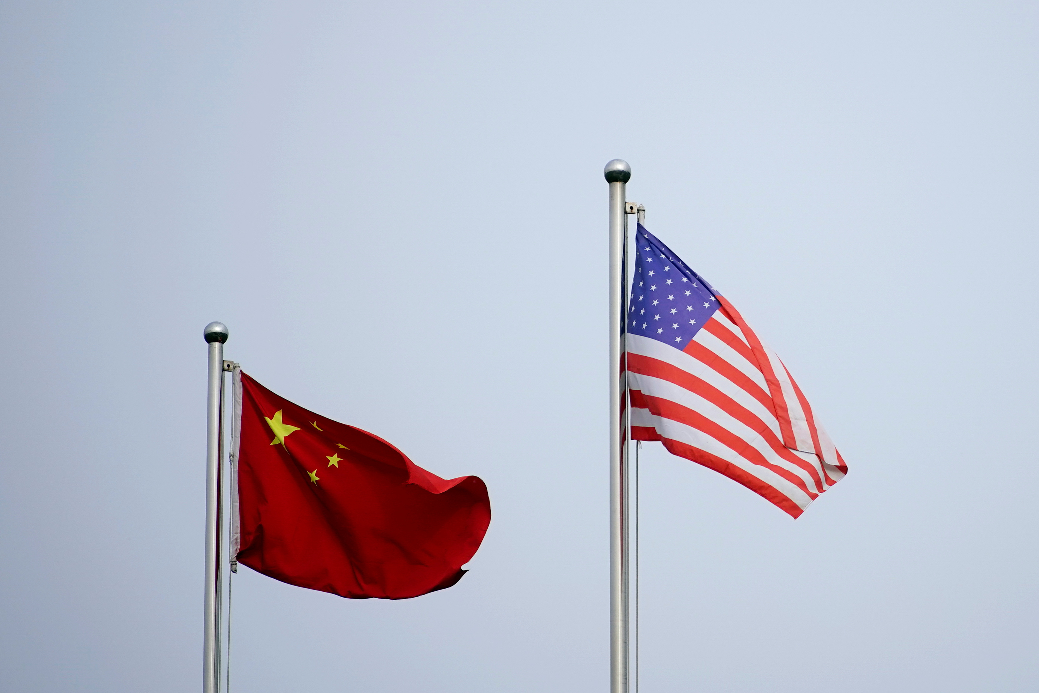 Chinese and U.S. flags flutter outside a company building in Shanghai