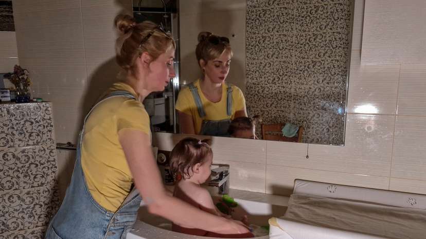 Woman cools 1-year-old daughter in a bathroom sink on an extremely hot day during power cuts in Kyiv