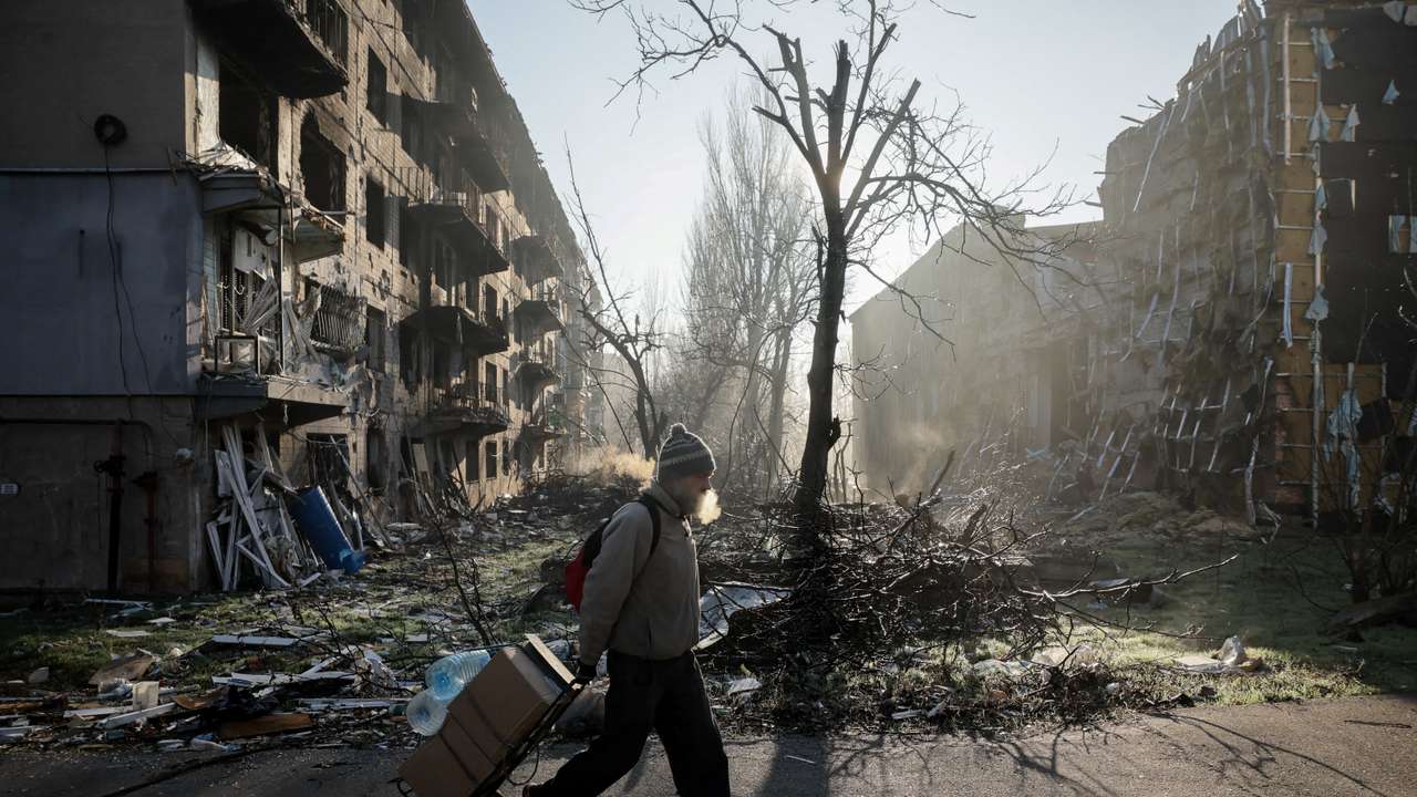 A resident walks near apartment buildings damaged by a Russian military strike in the frontline town of Kostiantynivka
