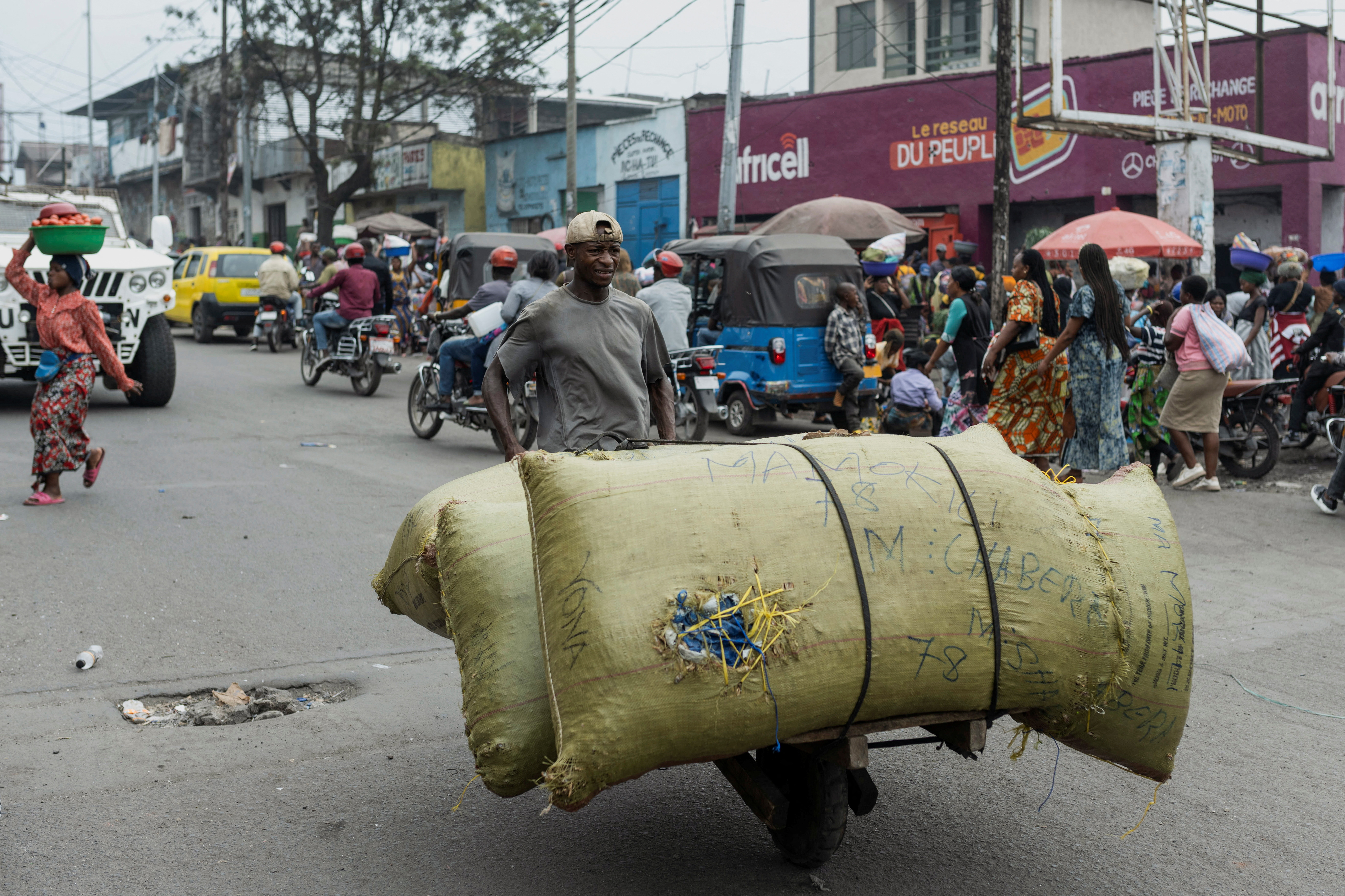 A man carries items on a handmade cart in a street of Birere market, days after the town of Goma was taken by M23 rebels