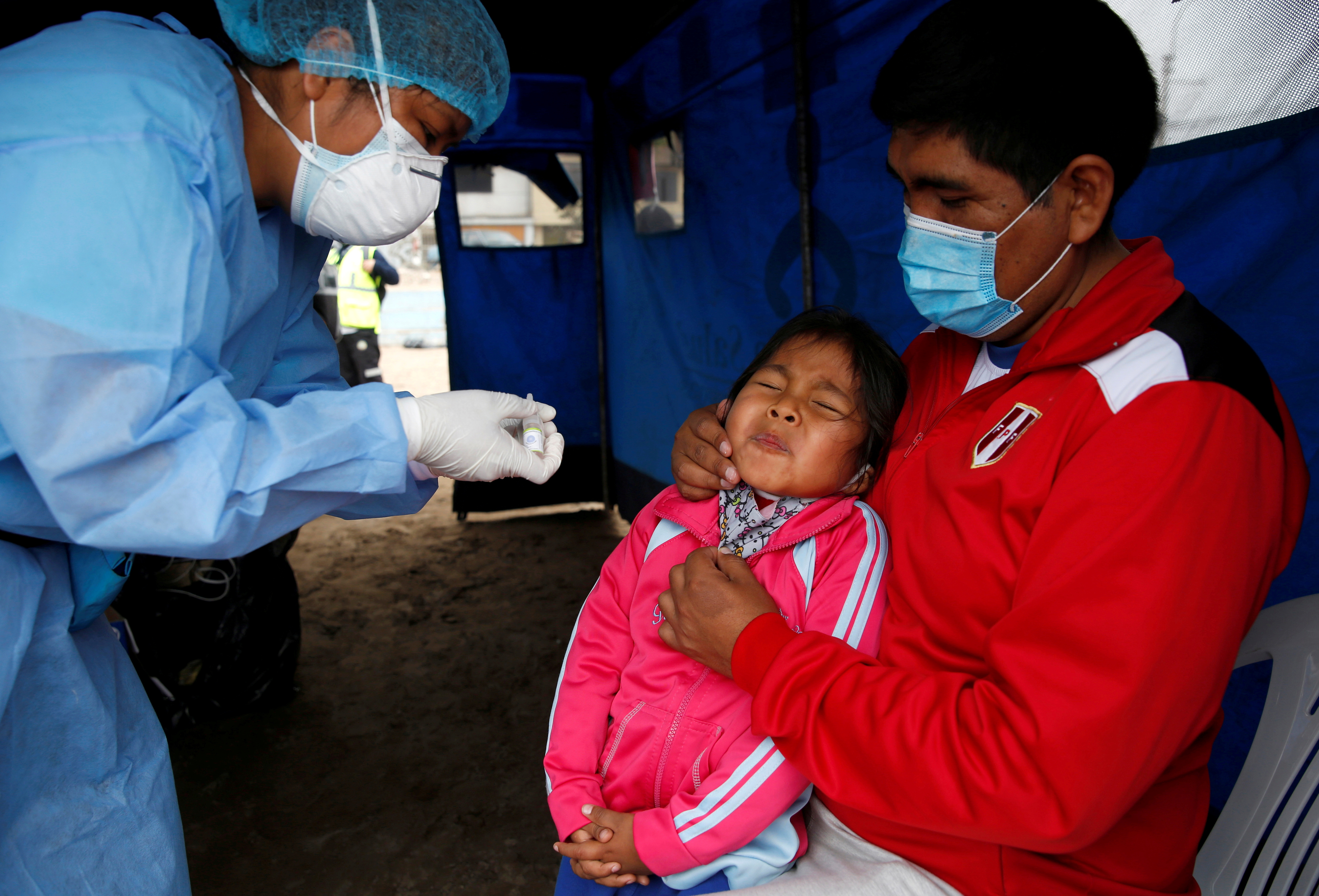 A little girl reacts after receiving an oral vaccine during a vaccination drive for diphtheria, influenza, tetanus and pneumococcus, after several new cases of diphtheria were identified, in Lima