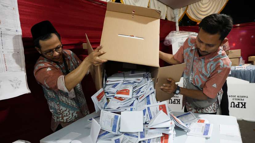 Electoral officers count votes at a polling station after general election polls closed in Jakarta