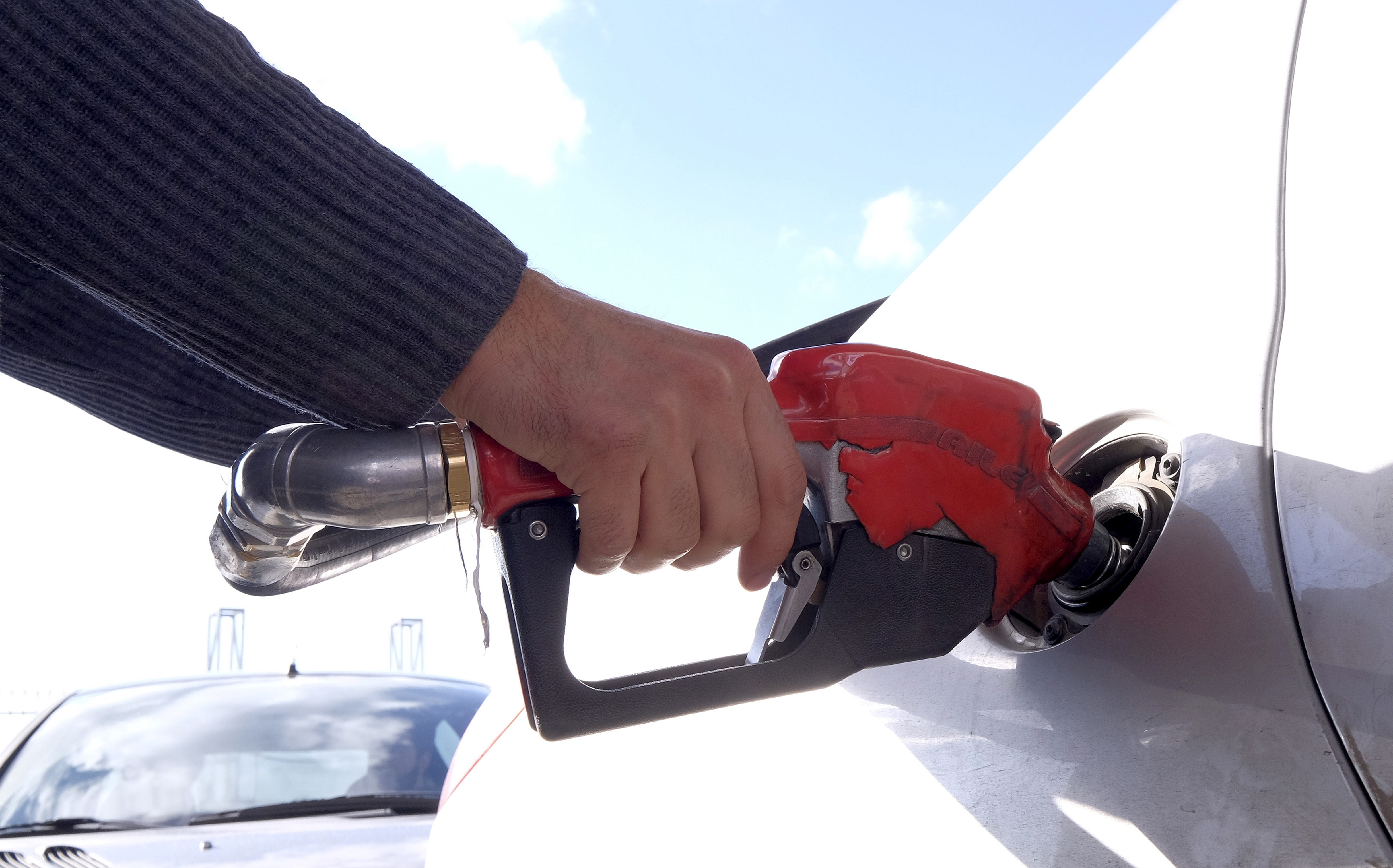 Man refuels his car at a petrol station in Tehran