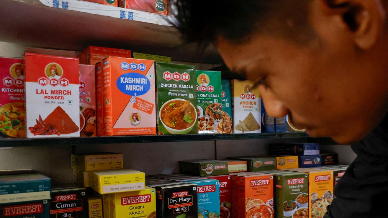 FILE PHOTO: FILE PHOTO: A man stands near the spice boxes of MDH and Everest kept on the shelf of a shop at a market in New Delhi