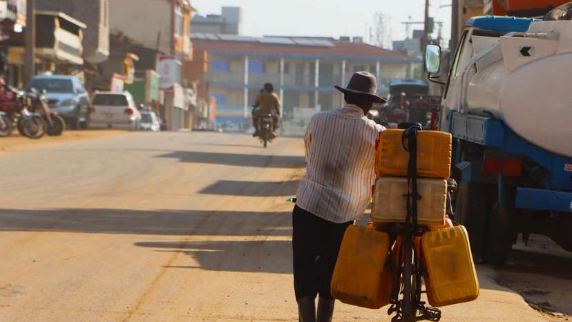A man pushes his bicycle with fuel jerrycans along a street in Juba