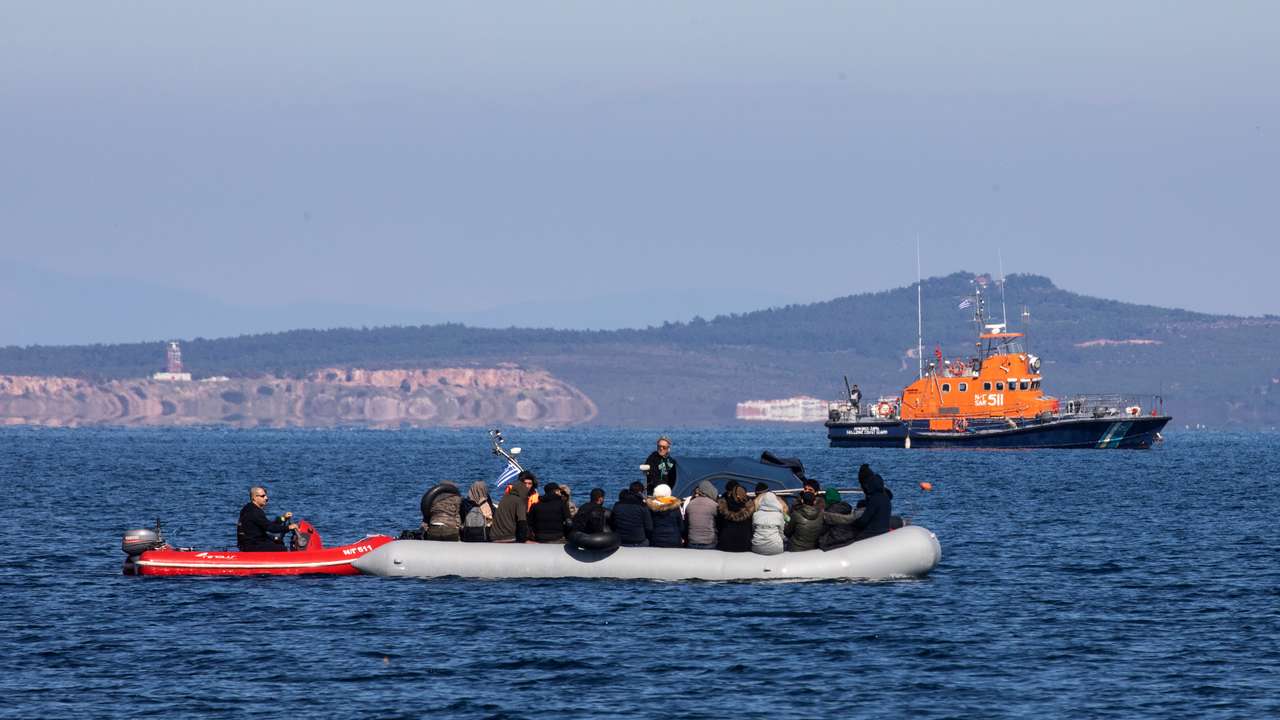 Migrants on a dinghy with a damaged engine are helped by coast guard rescuers to reach the port of Thermi, as they cross part of the Aegean Sea from Turkey to the island of Lesbos