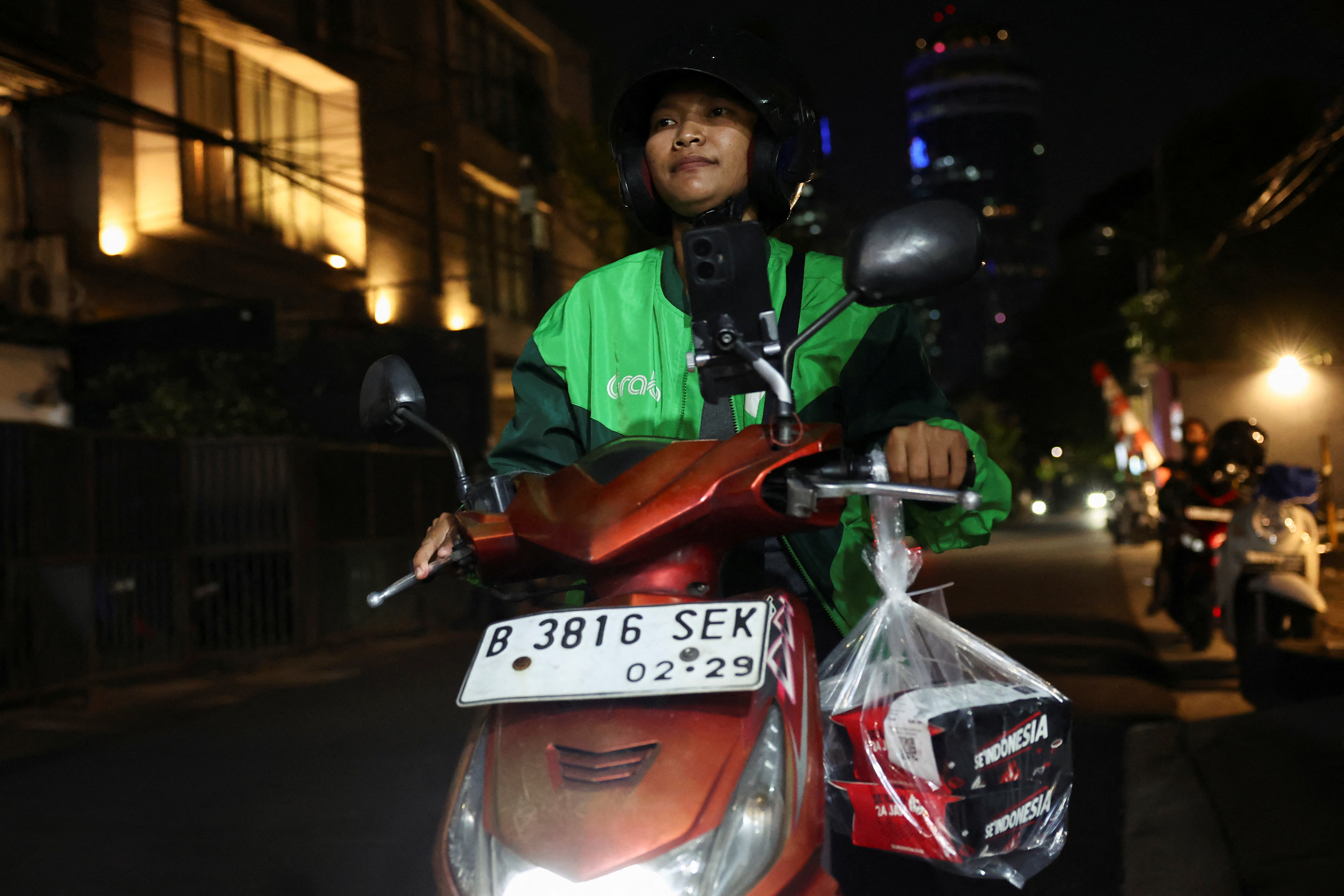 Ride-hailing motorbike drivers receive donated food through the apps in solidarity amid widespread protests, in Jakarta