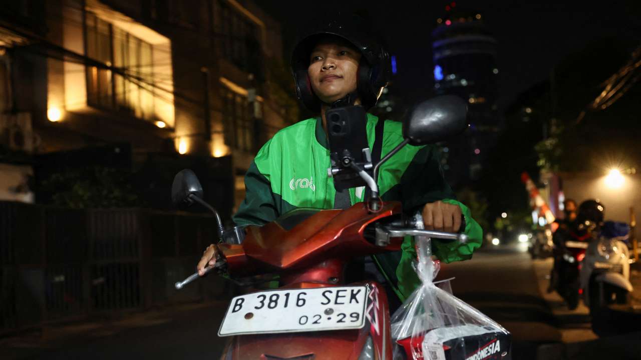 Ride-hailing motorbike drivers receive donated food through the apps in solidarity amid widespread protests, in Jakarta