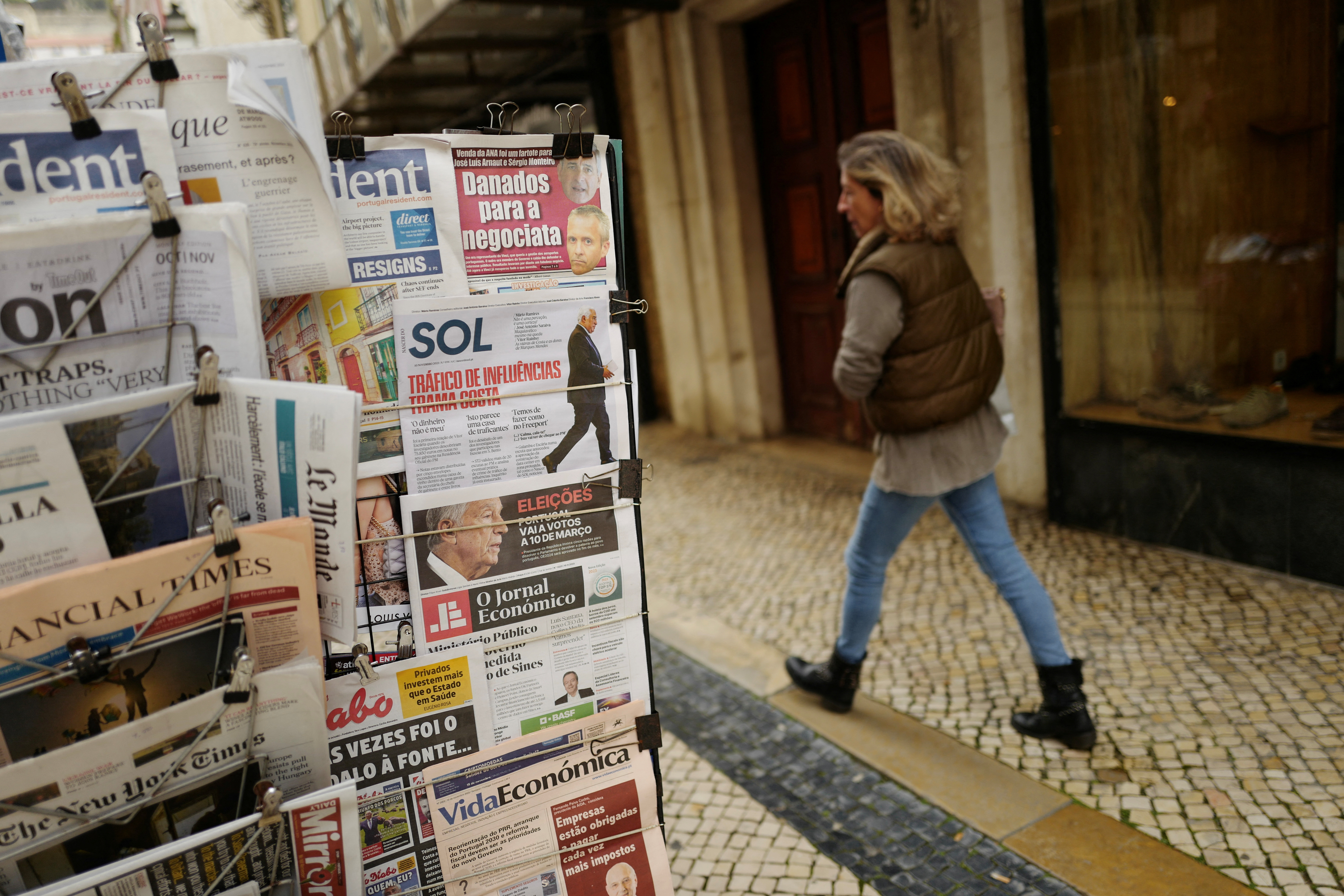 A woman passes by a newspaper stand, a day after Portugal's President Marcelo Rebelo de Sousa announced his decision to dissolve parliament triggering snap general elections on March 10th 2024, in Lisbon
