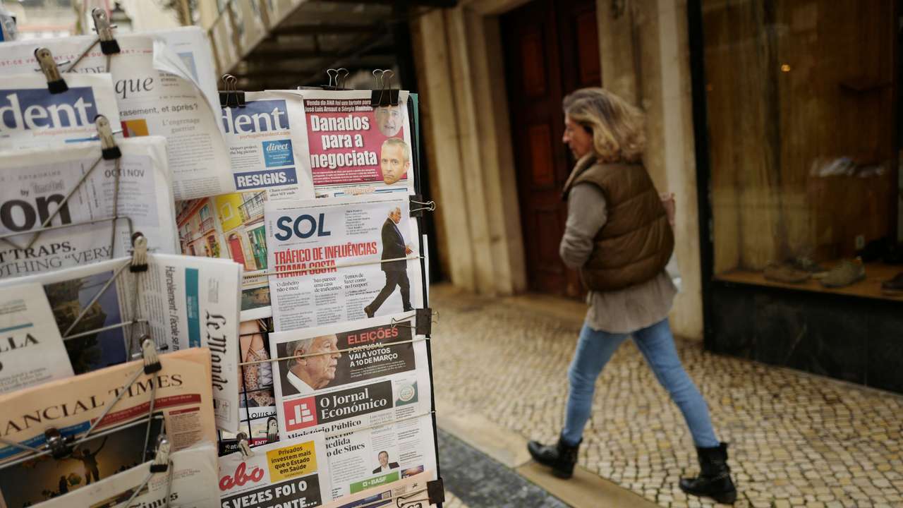 A woman passes by a newspaper stand, a day after Portugal's President Marcelo Rebelo de Sousa announced his decision to dissolve parliament triggering snap general elections on March 10th 2024, in Lisbon