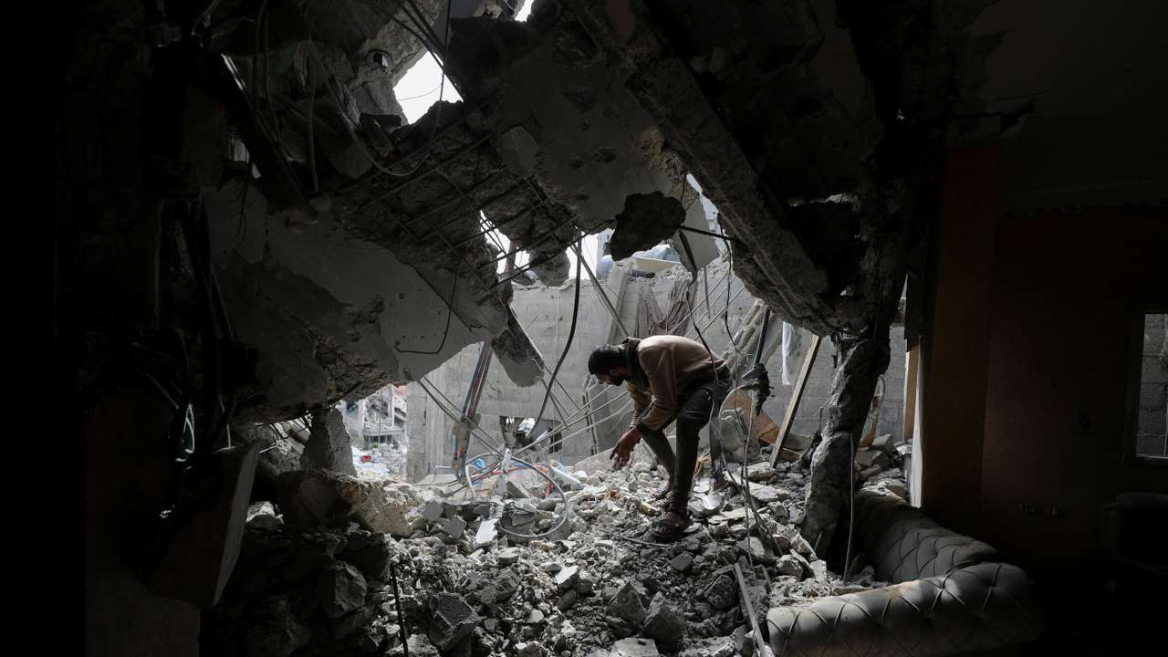 Palestinians inspect the site of an Israeli strike on a house, in Gaza City