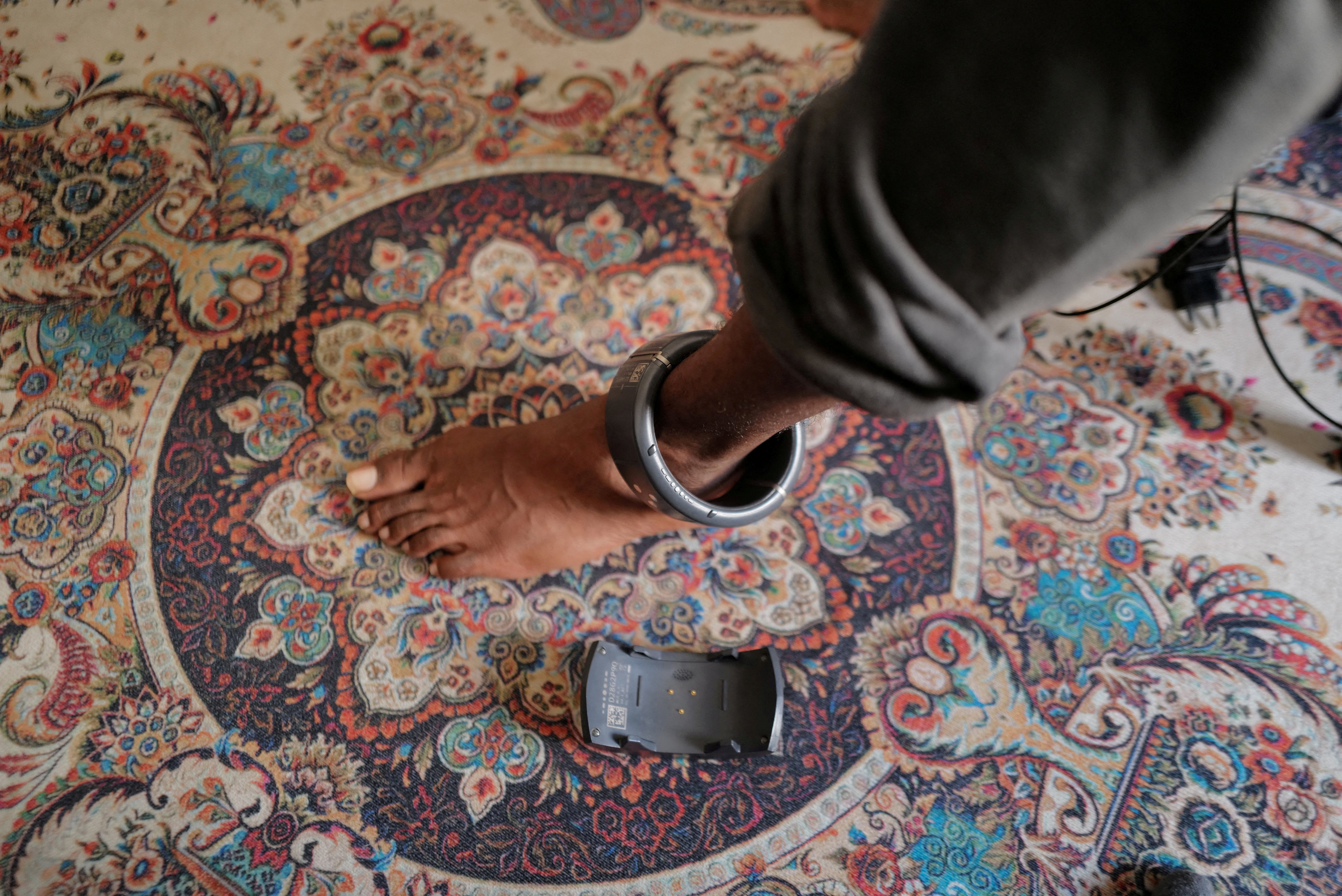 A detainee who is monitored with an electronic anklet monitor is pictured at their house during an interview with journalists after they were released under a program that aims to decongest prisons, in Dakar