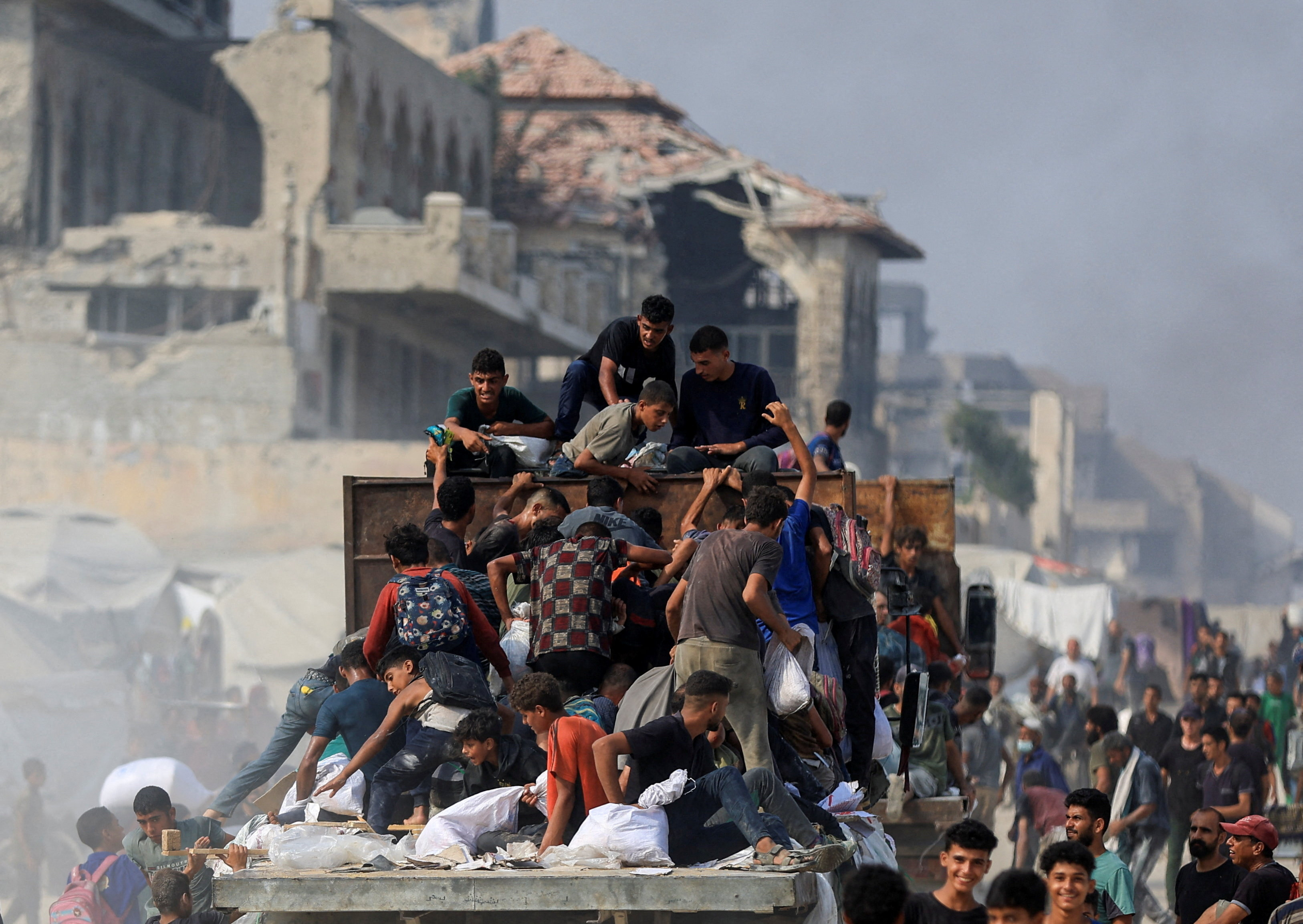 Palestinians seek aid supplies from trucks that entered Gaza through Israel, in Beit Lahia, in the northern Gaza Strip