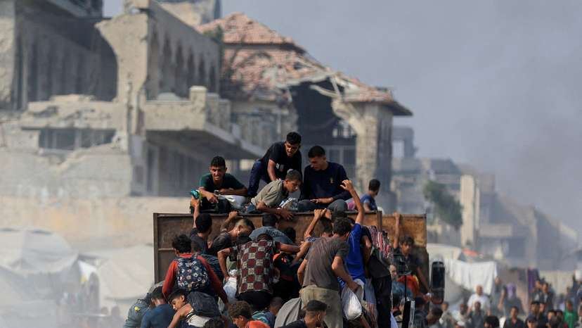 Palestinians seek aid supplies from trucks that entered Gaza through Israel, in Beit Lahia, in the northern Gaza Strip