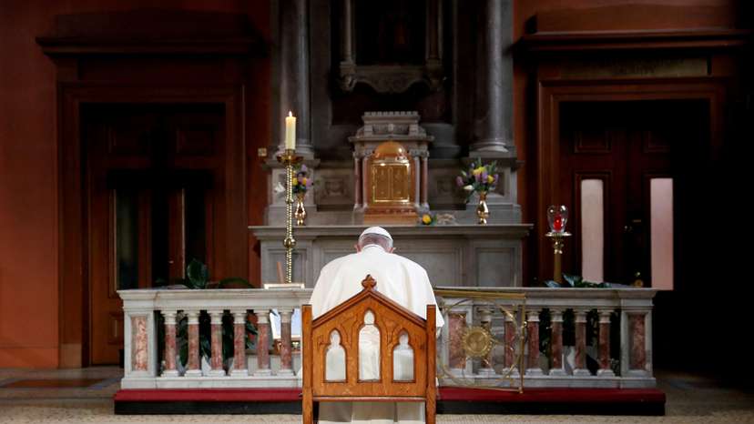 FILE PHOTO: Pope Francis prays in front of a candle lit to remember victims of abuse by the church, inside St Mary's Pro Cathedral during his visit to Dublin