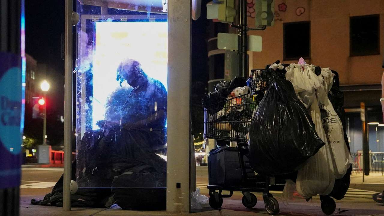 FILE PHOTO: A homeless person sits at a bustop in Dupont Circle, in Washington