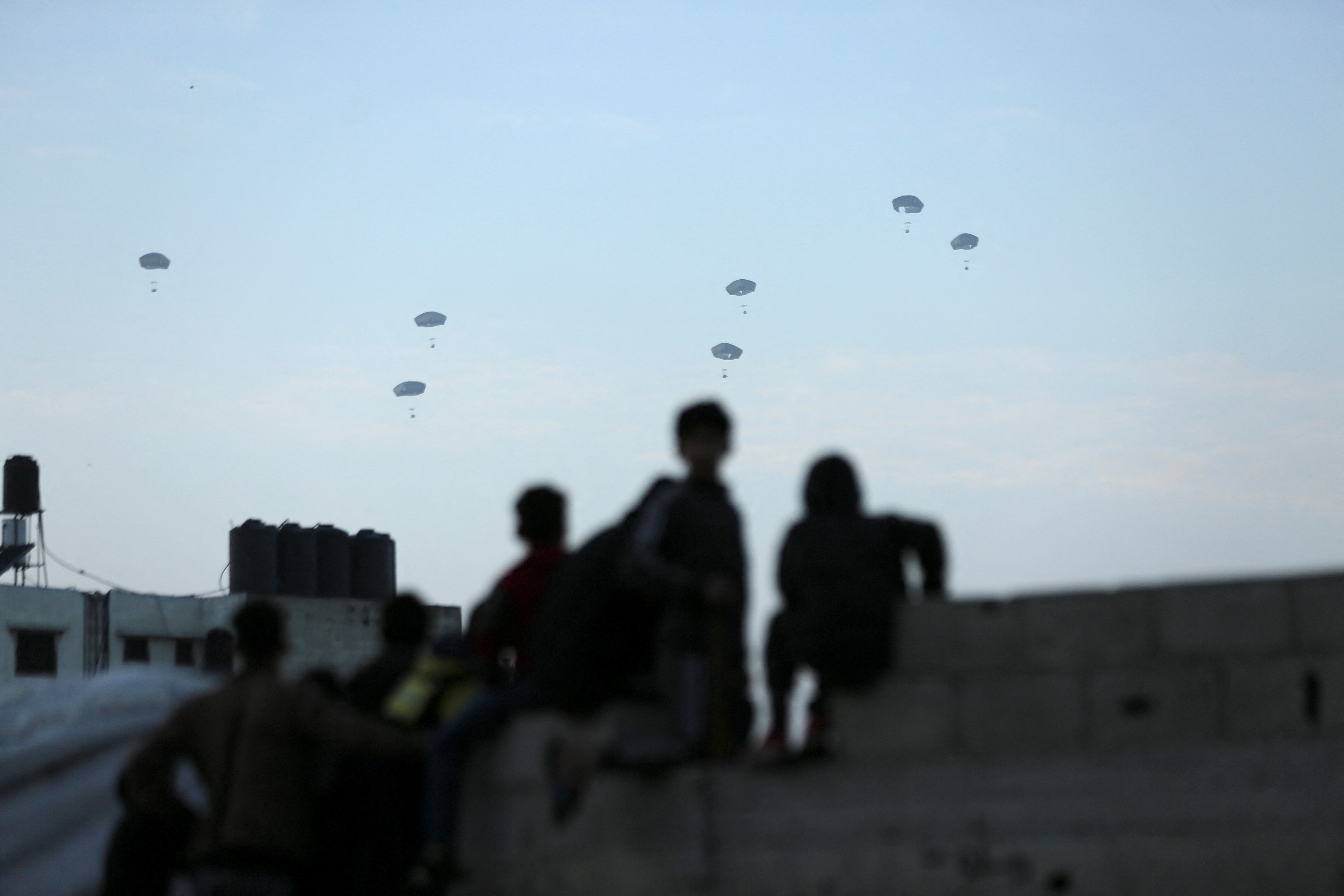 People watch as U.S. military carries out its first aid drop over Gaza, amid the ongoing the conflict between Israel and the Palestinian Islamist group Hamas, in Gaza City