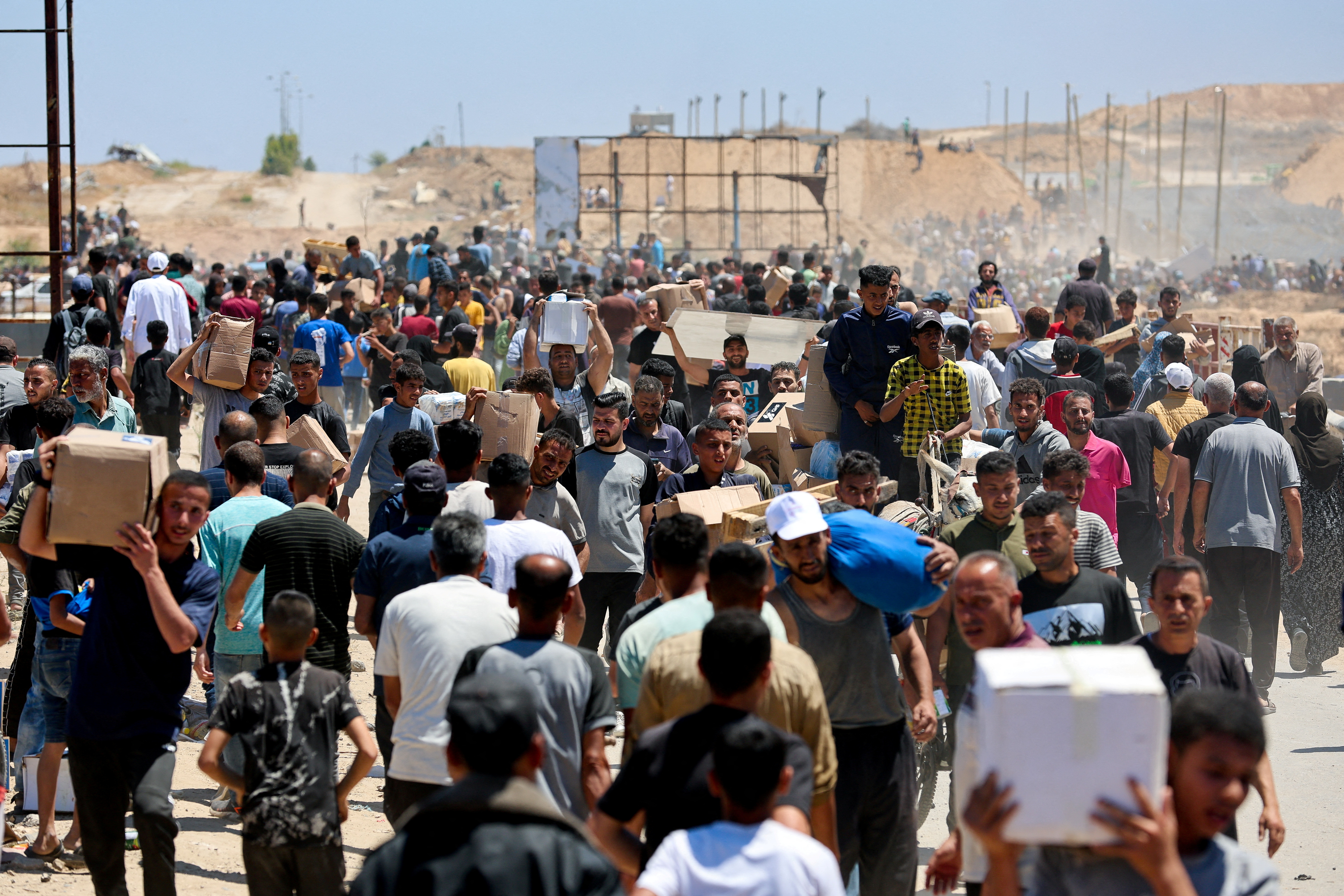 Palestinians carry aid supplies which they received from the U.S.-backed Gaza Humanitarian Foundation