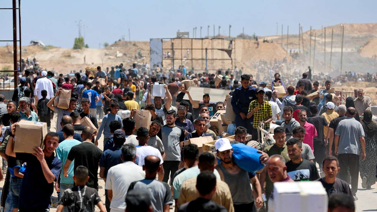 Palestinians carry aid supplies which they received from the U.S.-backed Gaza Humanitarian Foundation