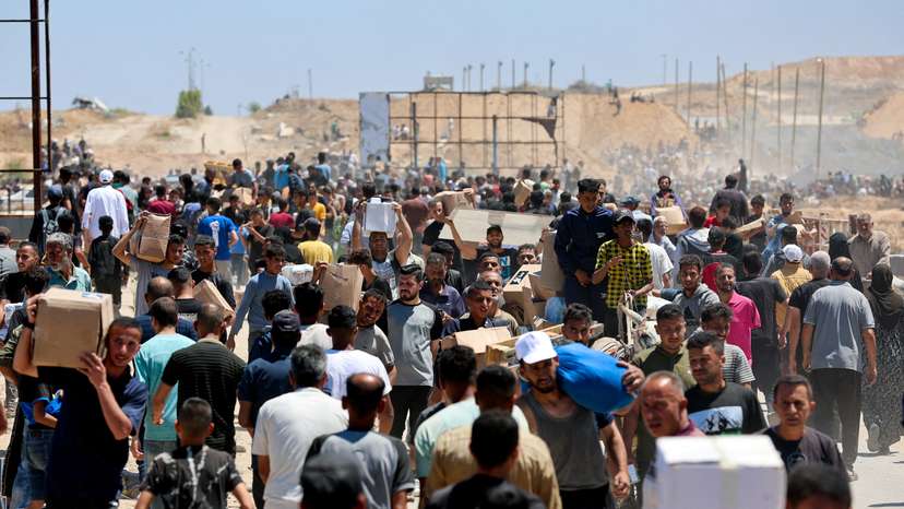 Palestinians carry aid supplies which they received from the U.S.-backed Gaza Humanitarian Foundation