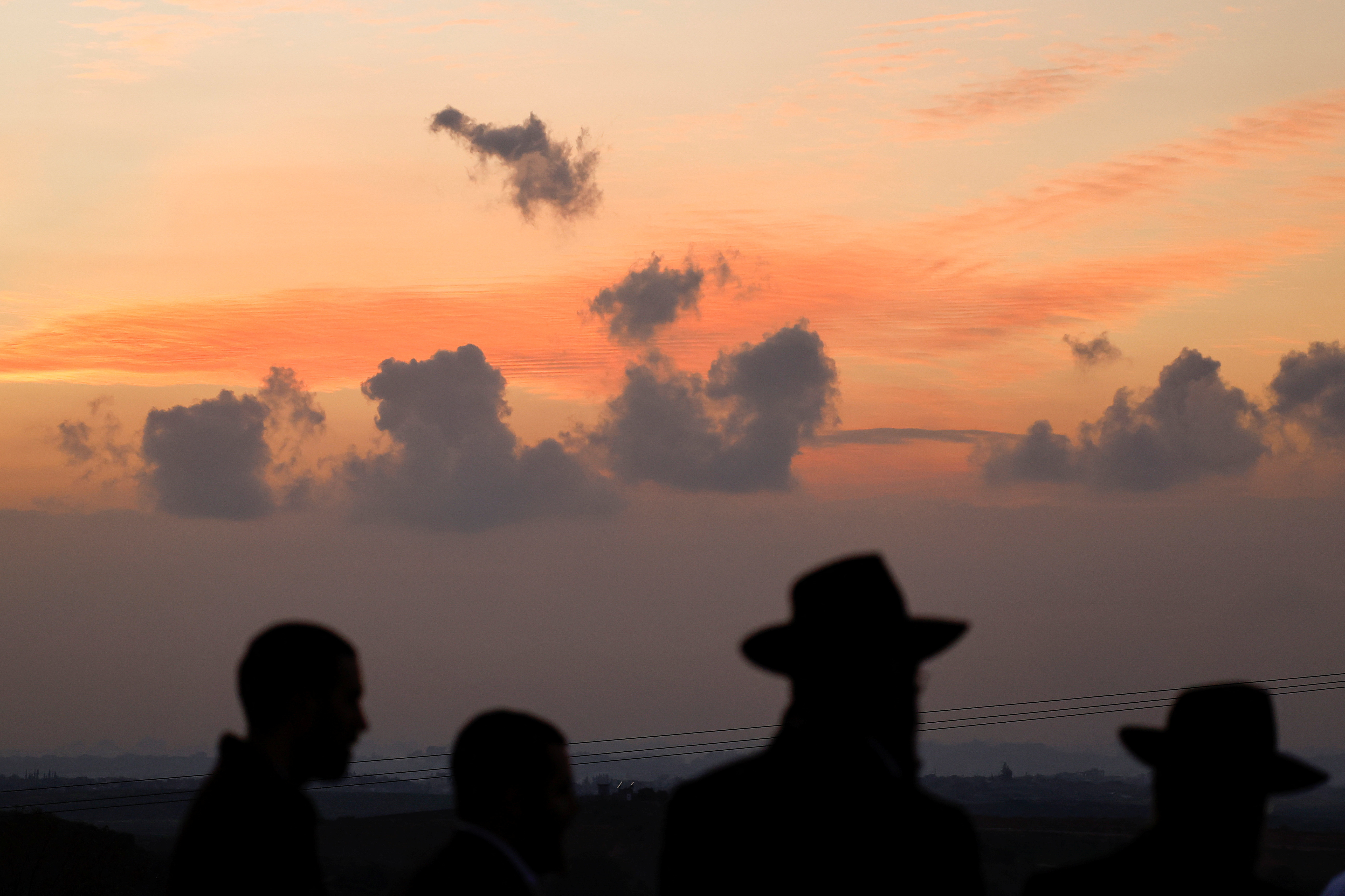 People look at the Gaza Strip from a viewpoint, amid the ongoing conflict between Israel and the Palestinian Islamist group Hamas, in Sderot