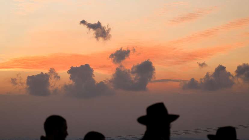 People look at the Gaza Strip from a viewpoint, amid the ongoing conflict between Israel and the Palestinian Islamist group Hamas, in Sderot