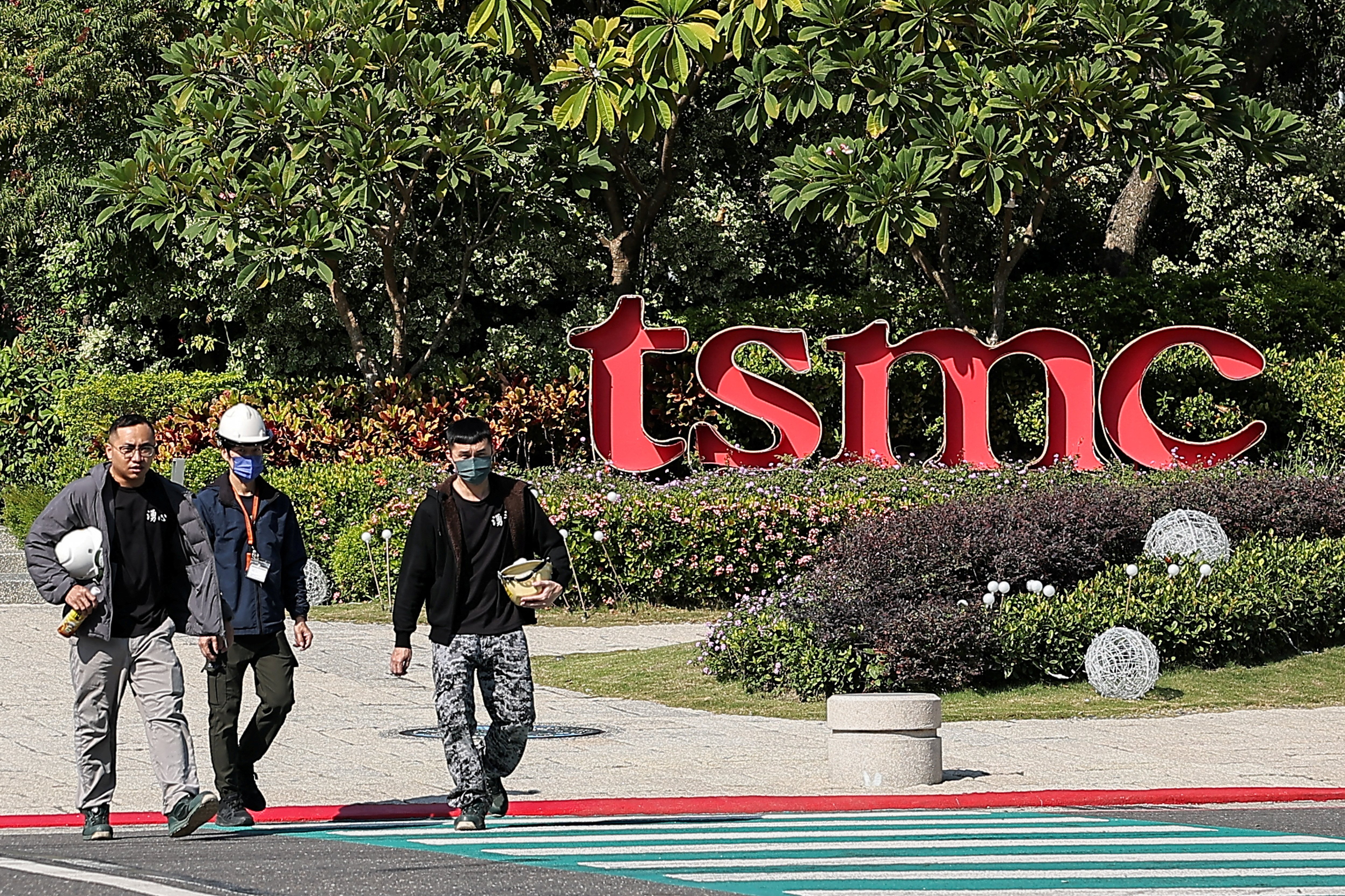 FILE PHOTO: People walk across the streets in front of TSMC Fab 18 at Southern Taiwan Science Park in Tainan