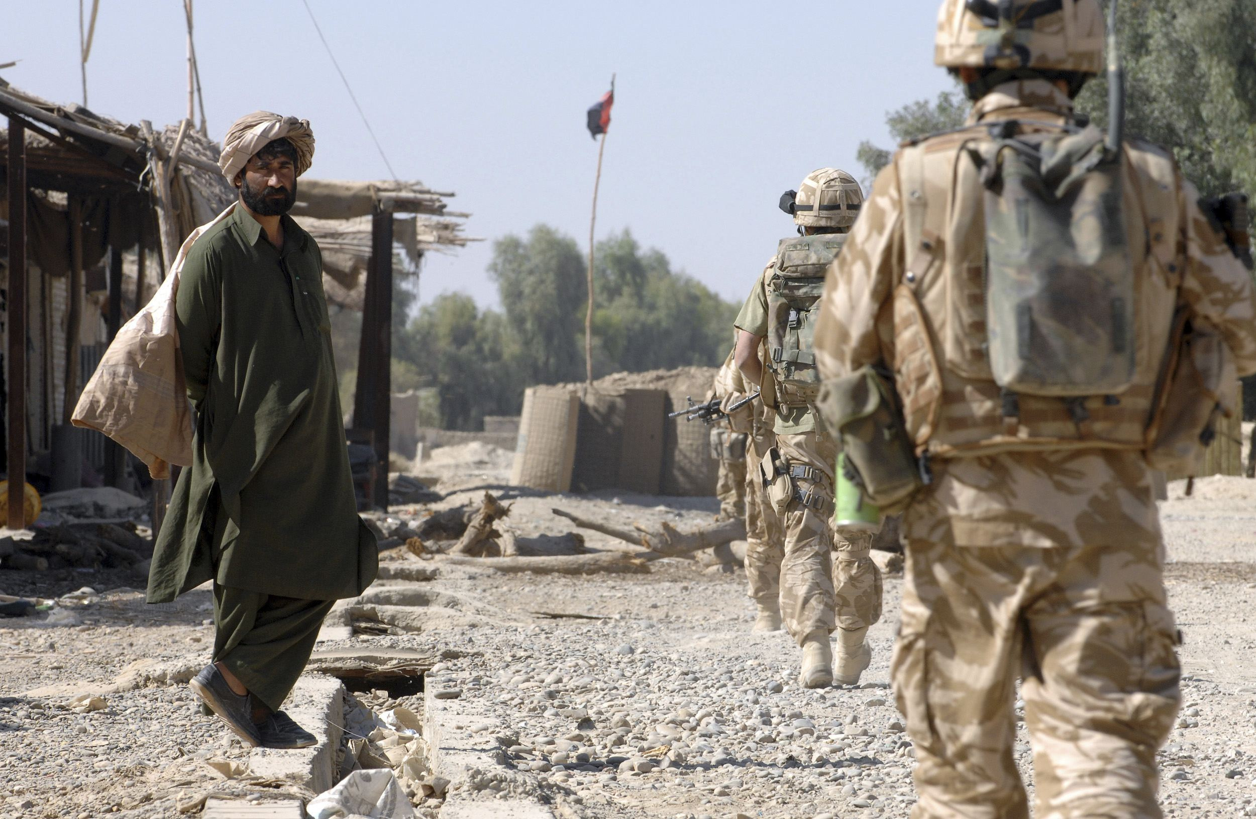 British Army Gurkha soldiers patrol through a deserted market street in southern Helmand